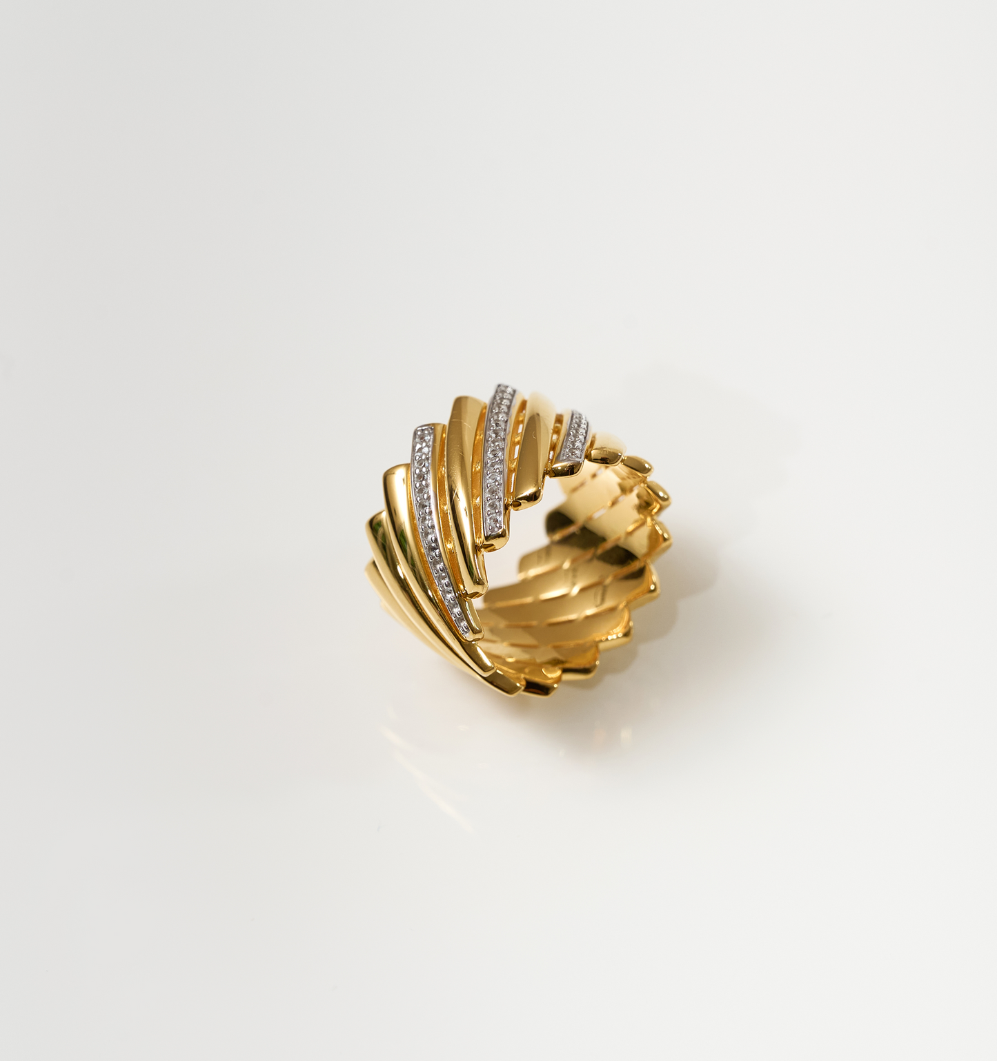 Gold Reya Ring with chevron curves and white topaz stones, radiant and fluid design