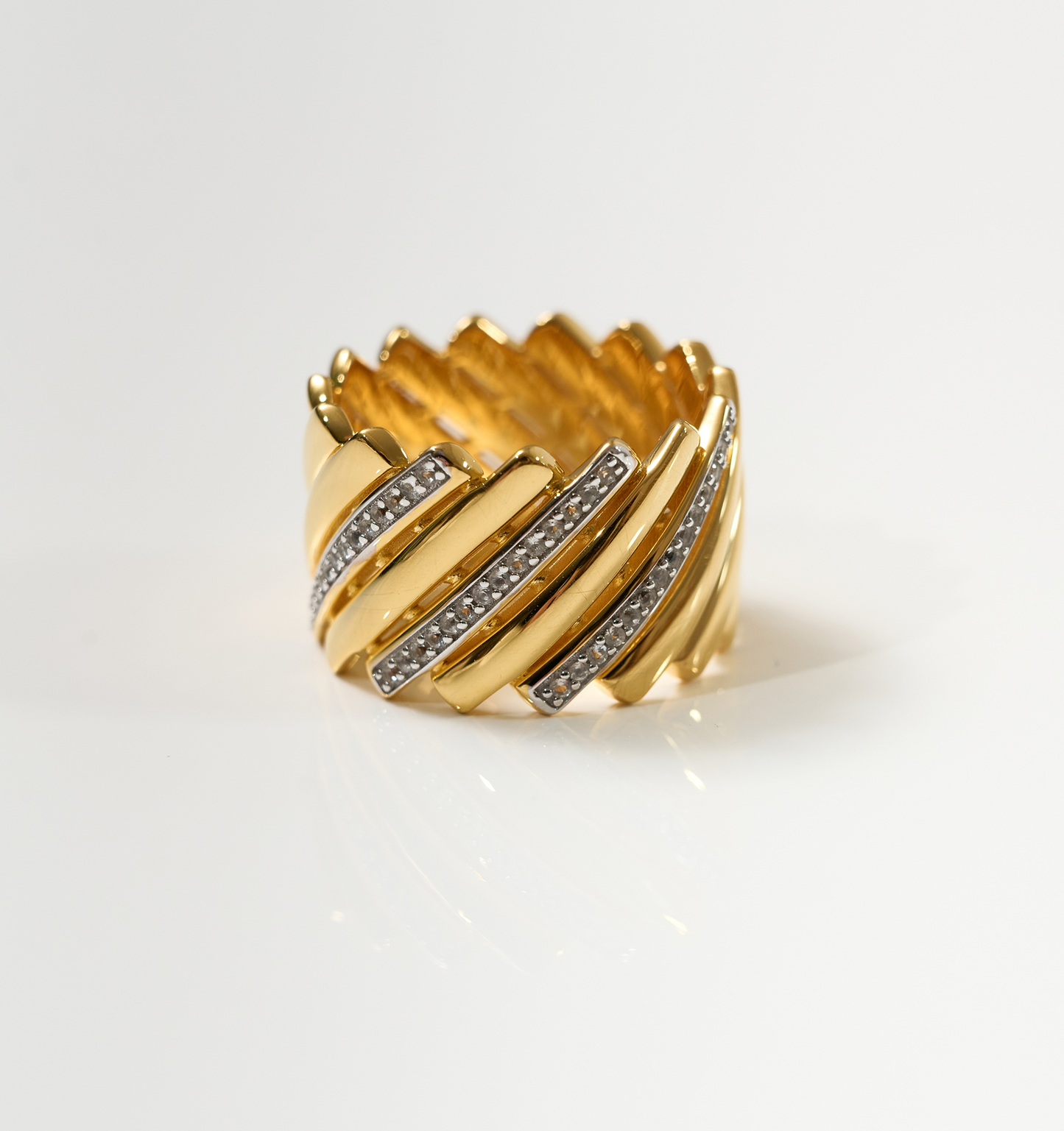Gold Reya Ring with chevron curves and white topaz stones, elegant and radiant design