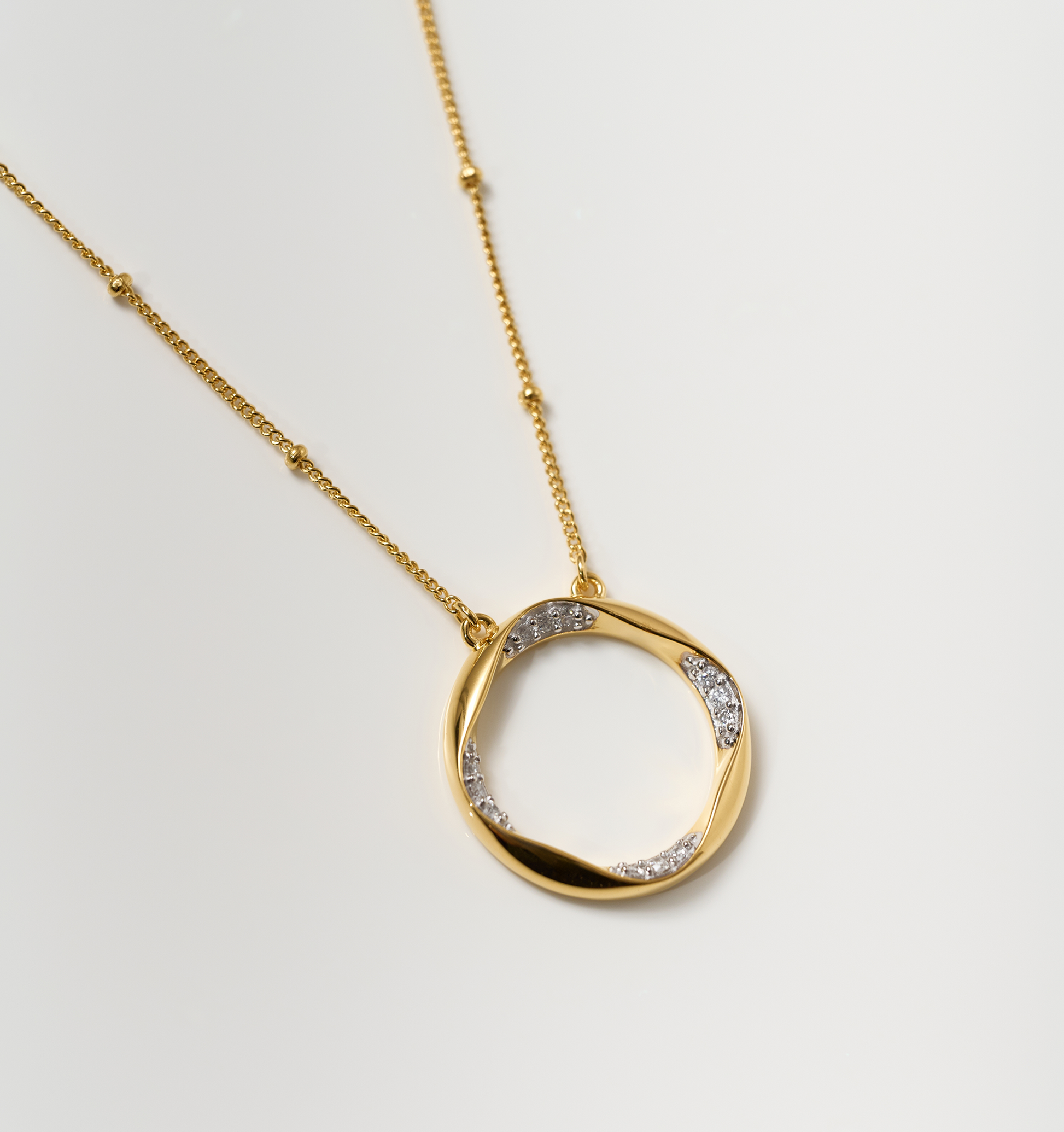 Taral Necklace elegant gold circle pendant with white topaz stones on delicate chain