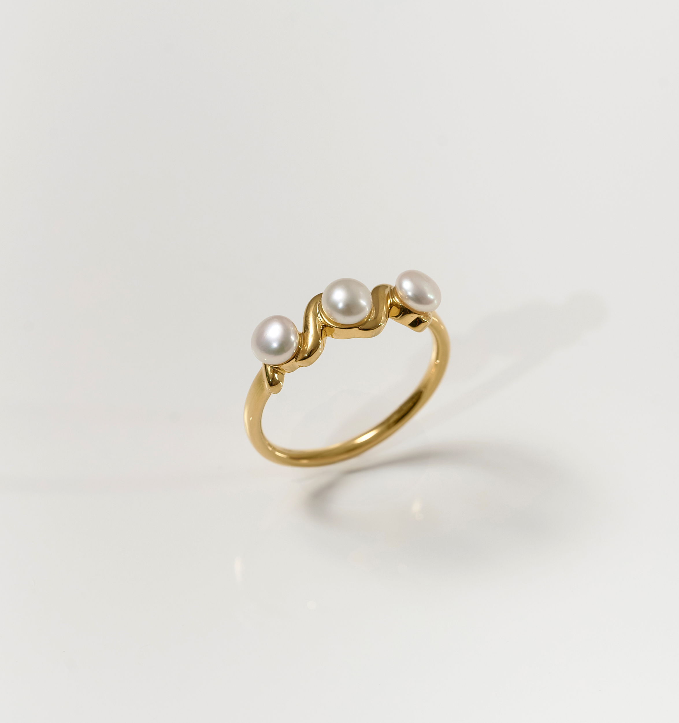 Tirya Ring elegant gold band with three pearls in a sculptural design