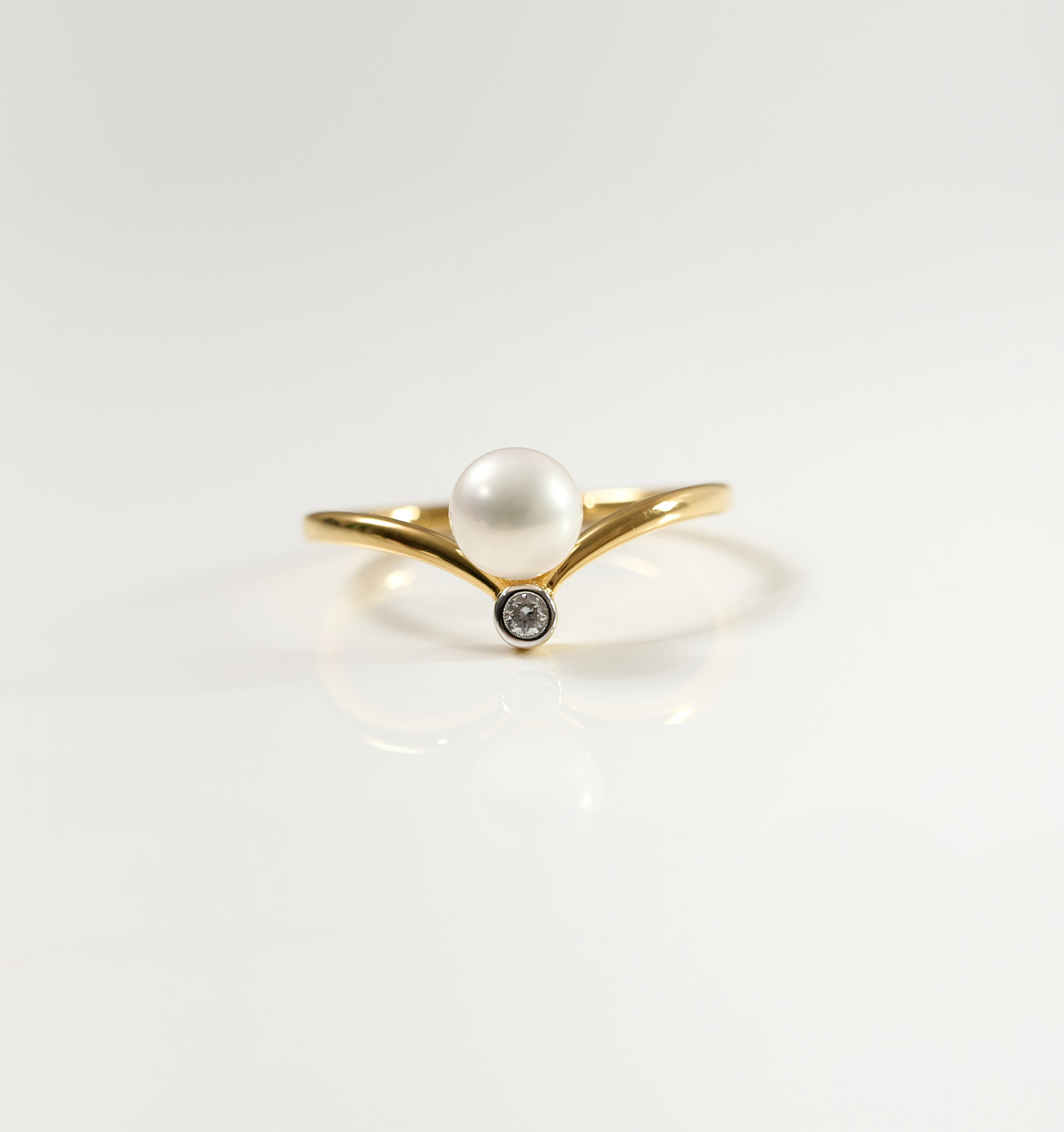 Sirna Ring with gold band, pearl centerpiece, and small star-shaped diamond detail