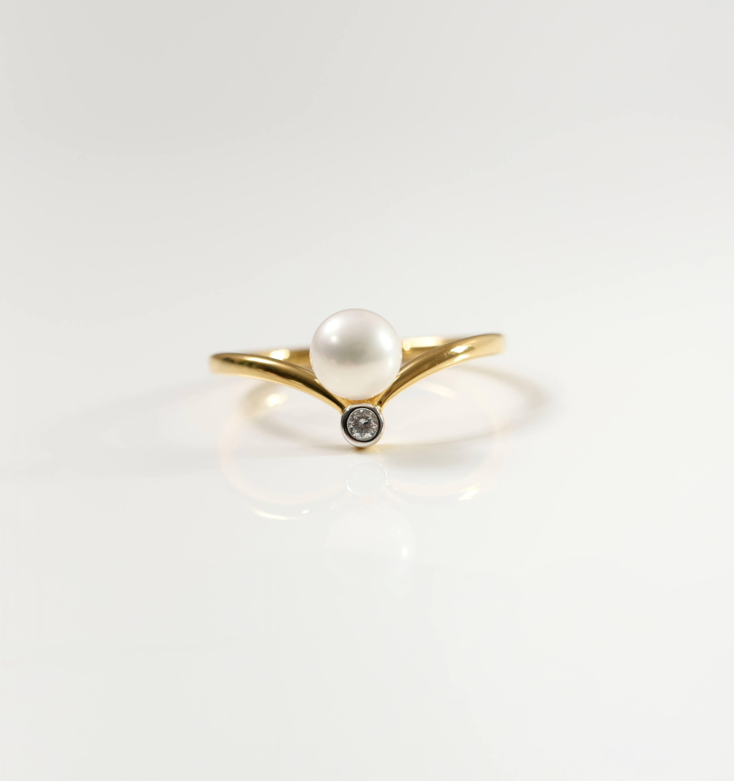 Sirna Ring with gold band, pearl centerpiece, and small star-shaped diamond detail
