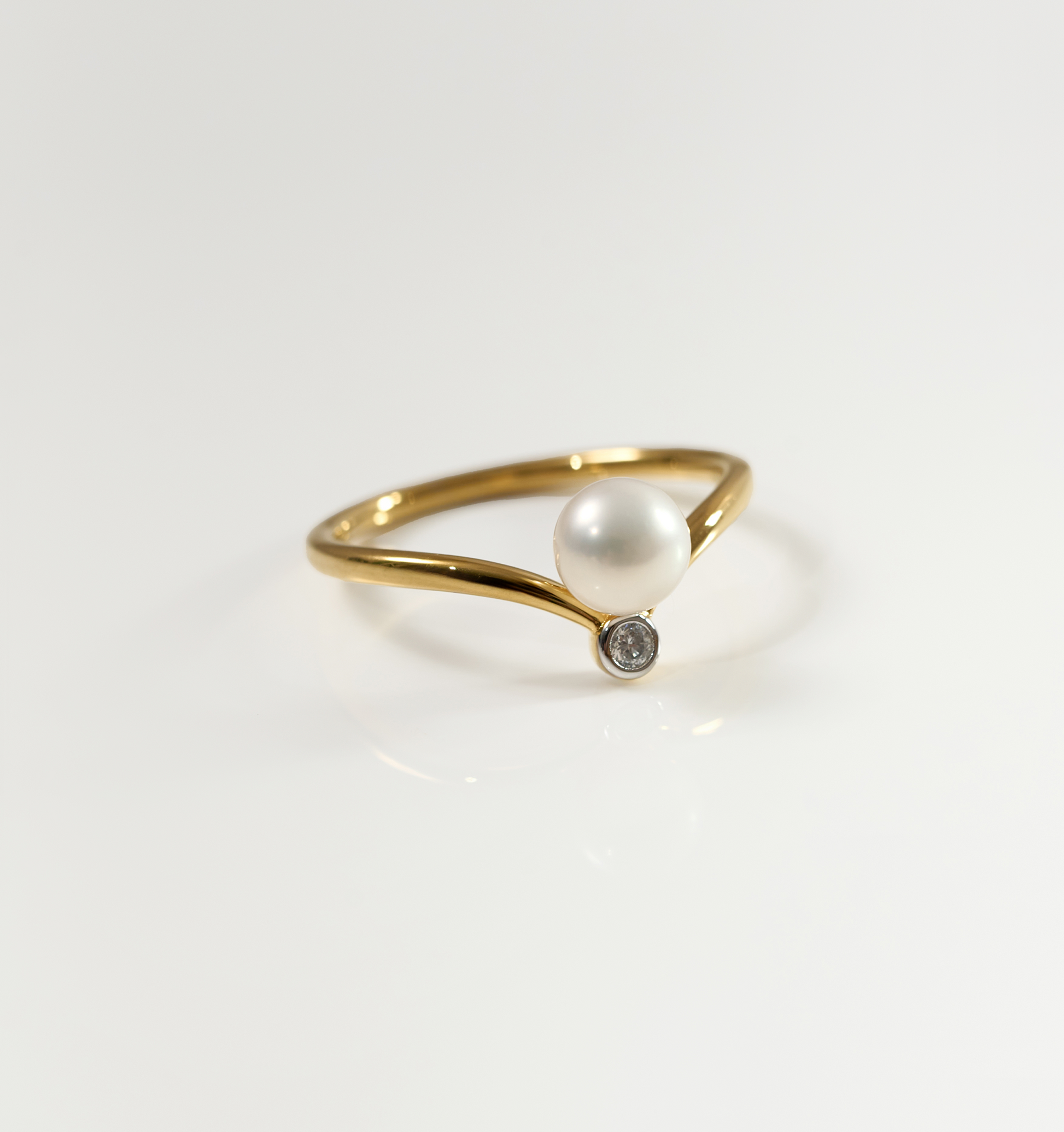 Sirna Ring gold band with pearl and small star diamond accent on white background