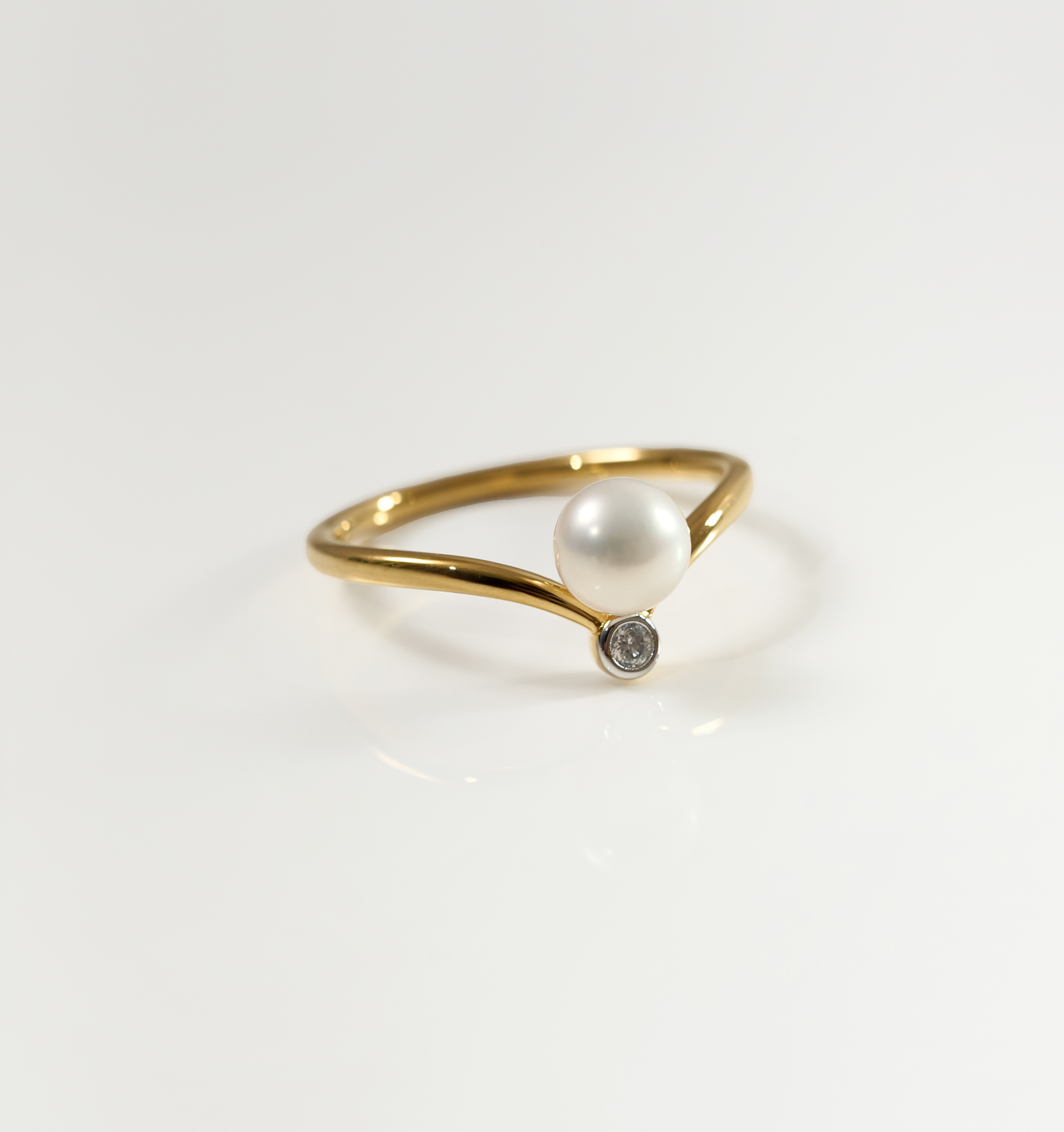 Sirna Ring gold band with pearl and small star diamond accent on white background