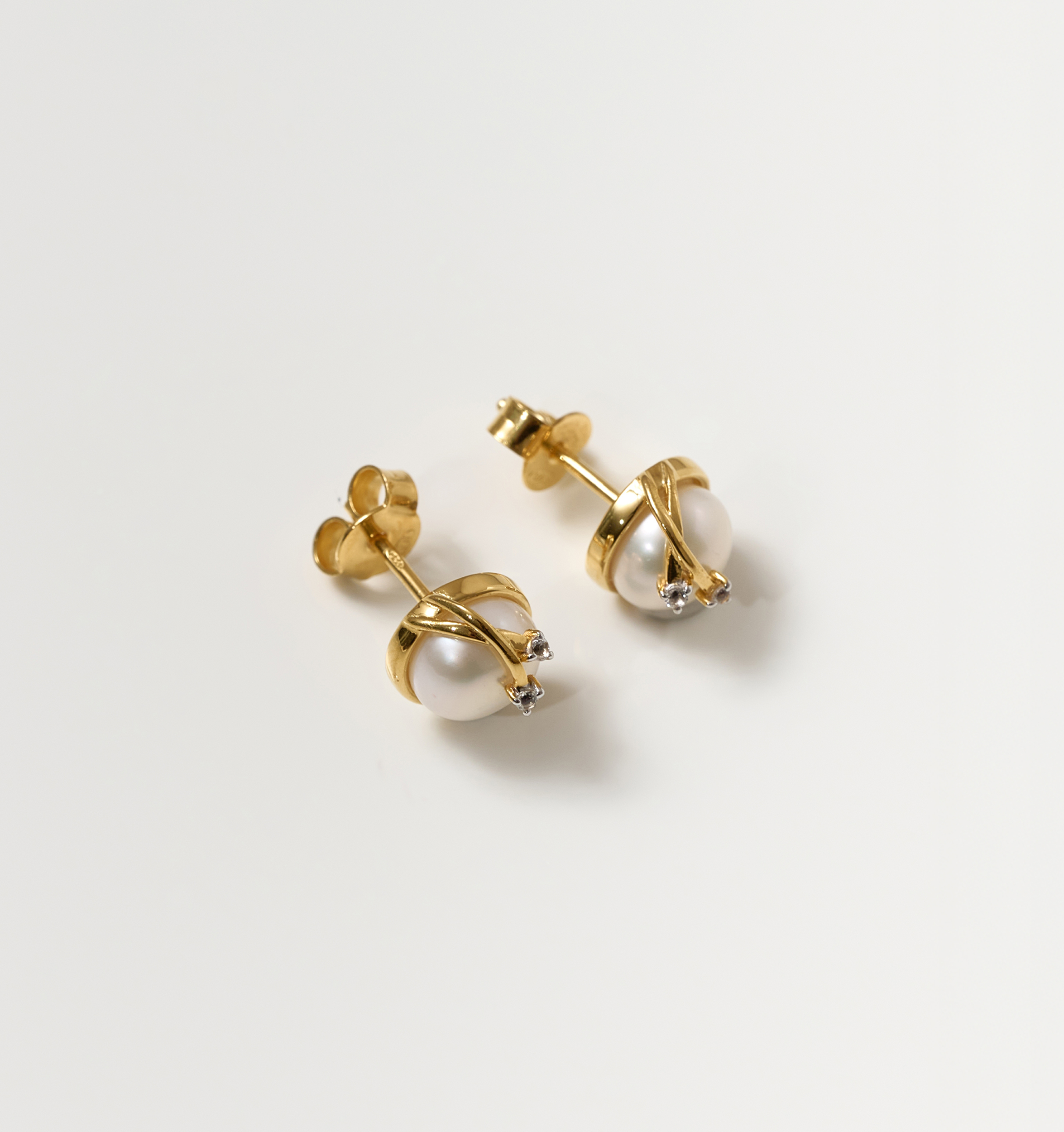 Poorna Earrings featuring gold settings with pearls and small star accents symbolizing completeness and grace.