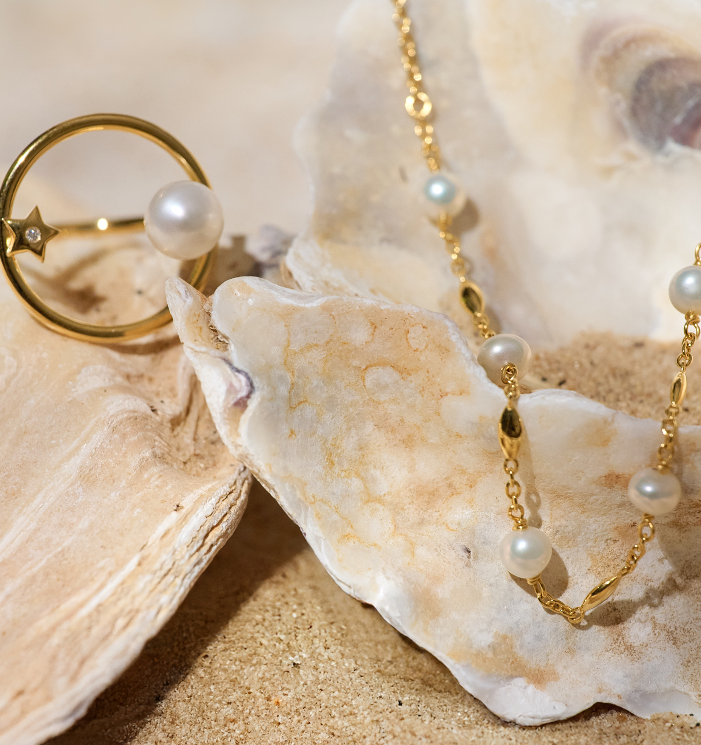 Manjari Necklace with five pearls and gold chain displayed on seashells