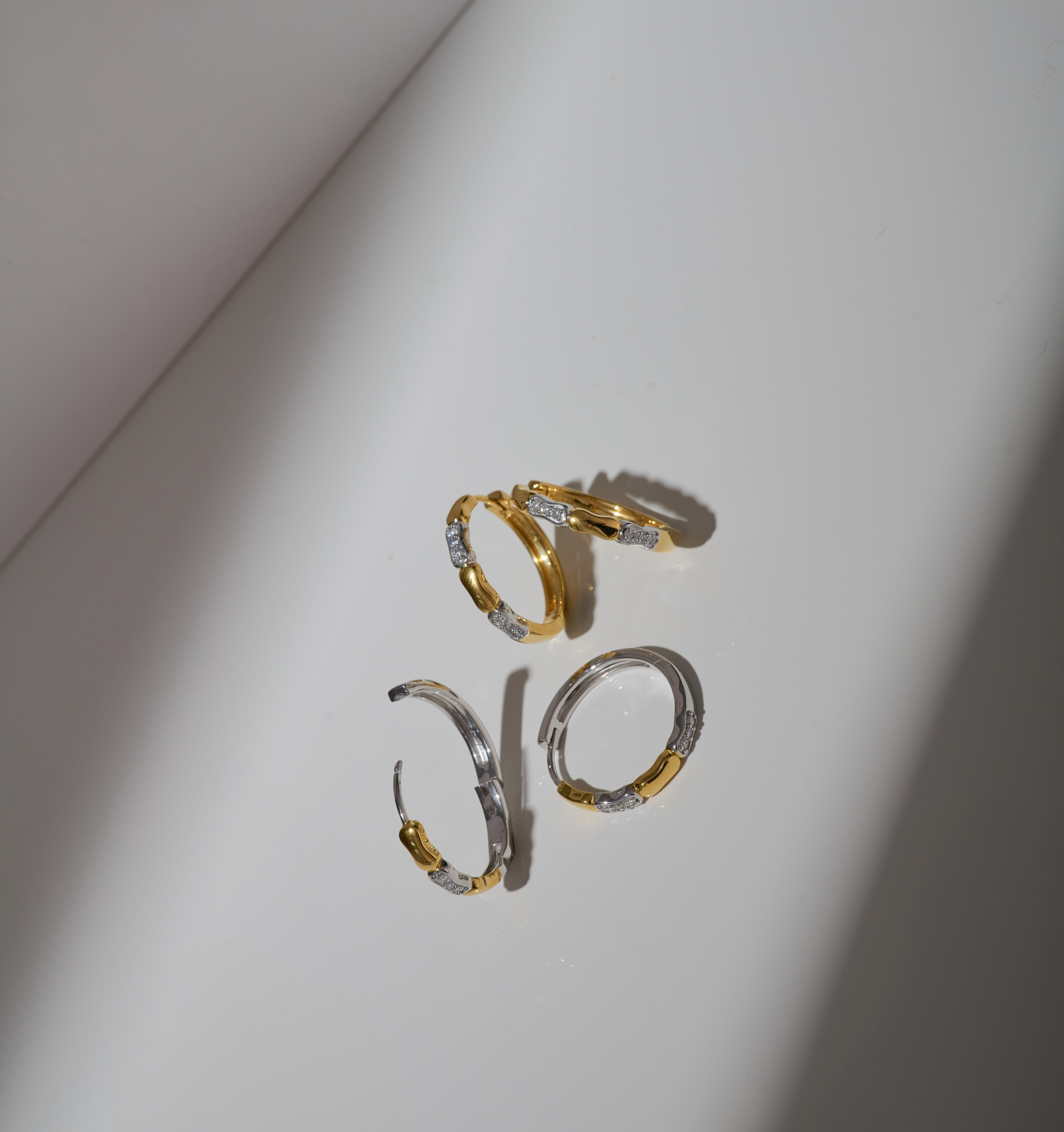 Orita Earrings gold and silver hoops with delicate stone accents on white background