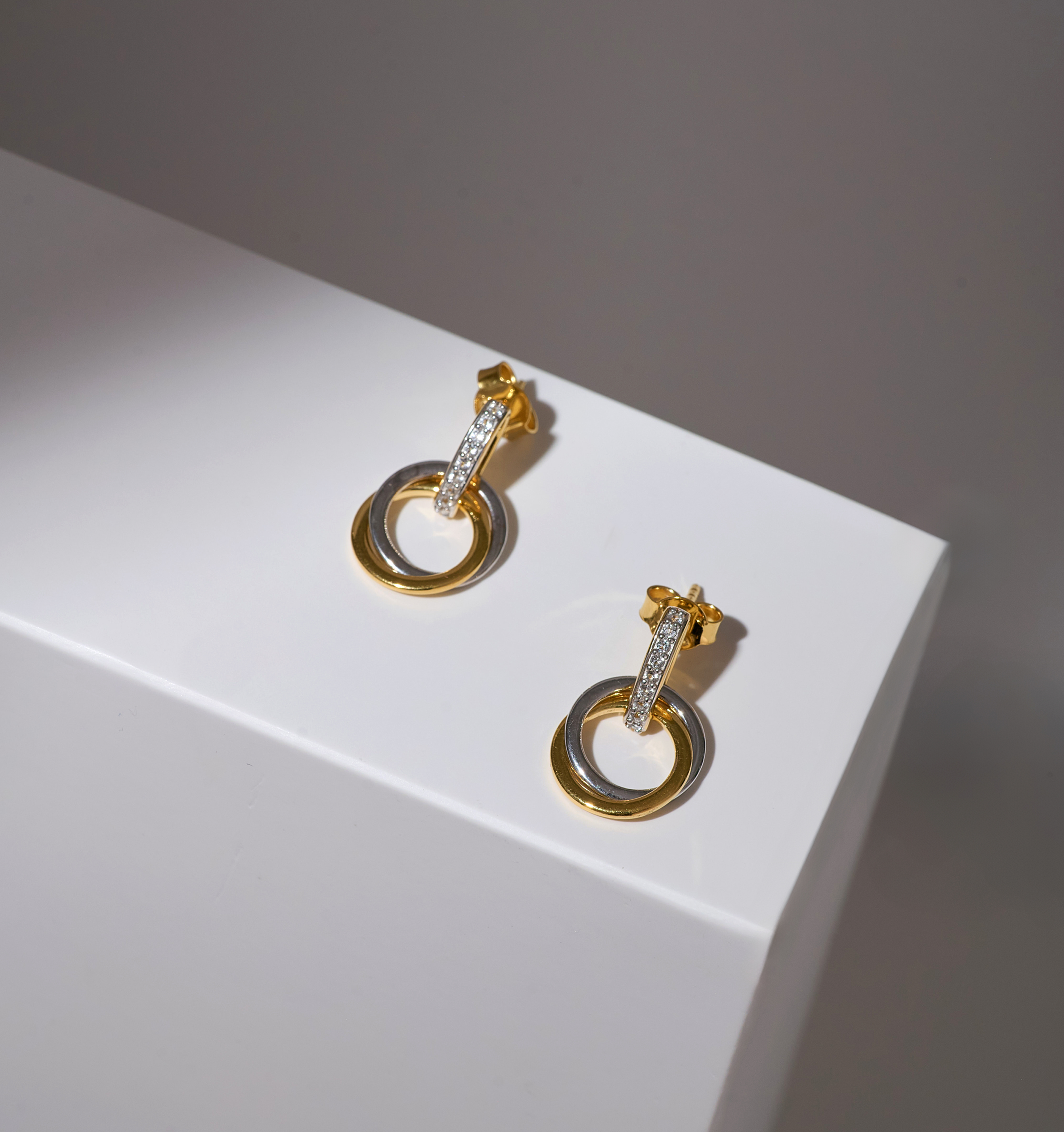 Nirya Earrings gold hoop design with diamond accents on white surface