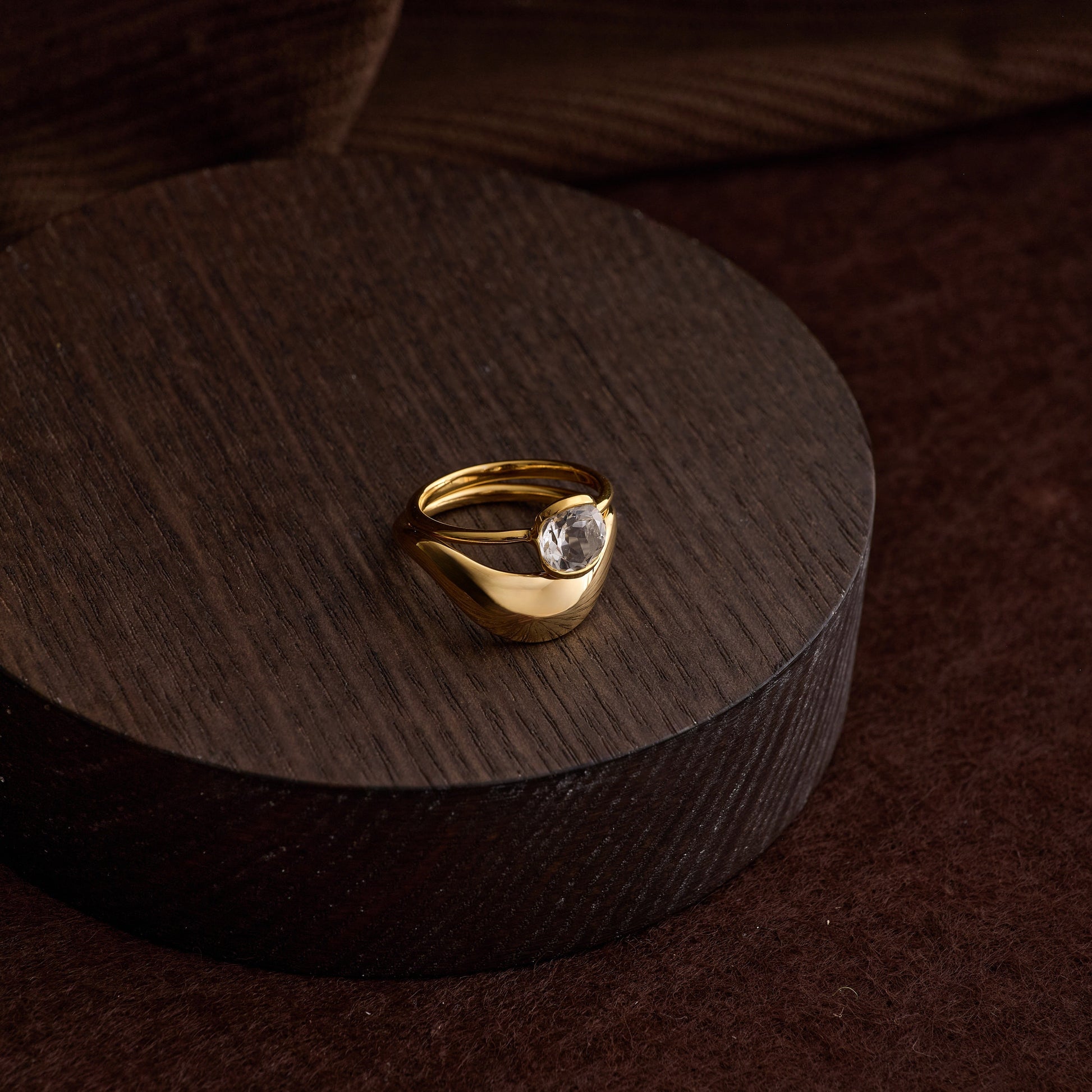 Gold Ruhi Ring with white topaz on dark wooden display block