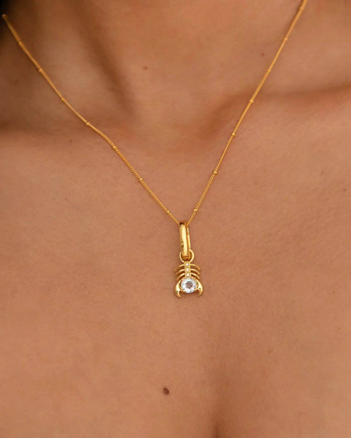 Scorpio Vrischika symbol with Mars, Sky Blue Topaz, and Diamond representing transformation and depth