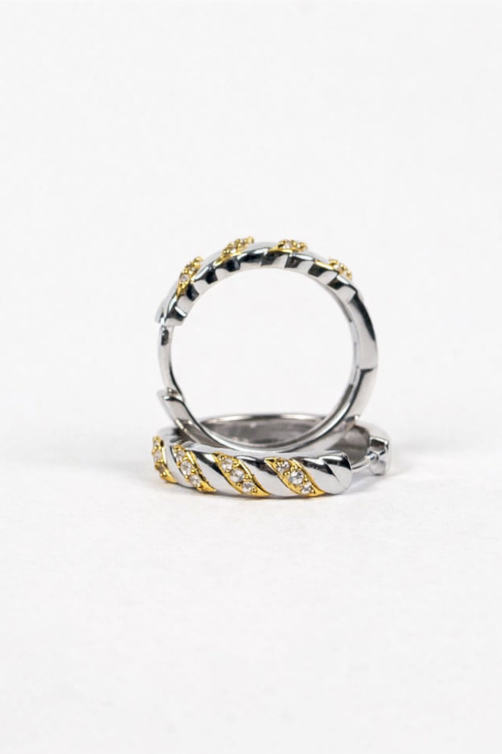 Aris Hoops earrings with white topaz stones and two-tone band showcasing modern contrast and elegance