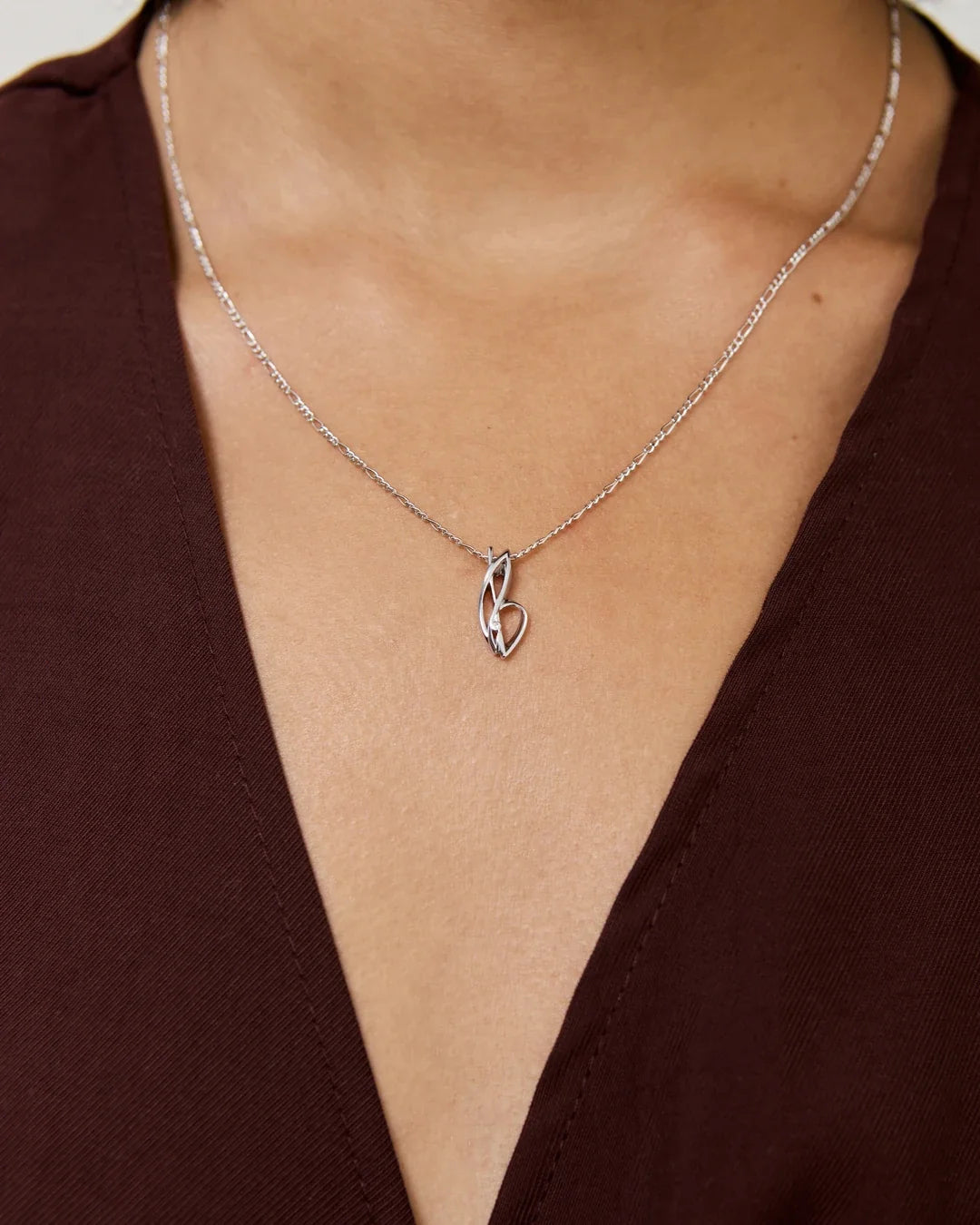 Silver B बी Initial Necklace with a delicate chain and polished pendant shaped as a stylized letter B.