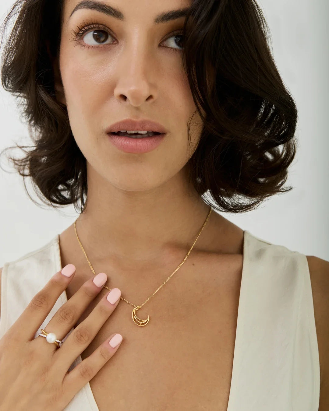 C सी Initial Necklace in delicate gold chain, featuring an open crescent-shaped letter pendant worn at the neck.