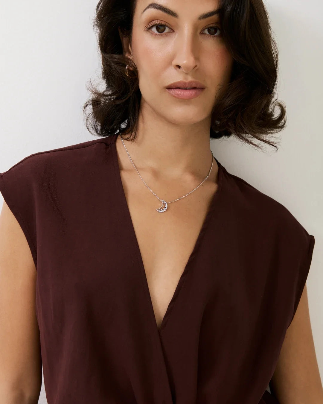 D डी Initial Necklace, a delicate silver-toned chain with a small crescent-shaped pendant and subtle sparkle.