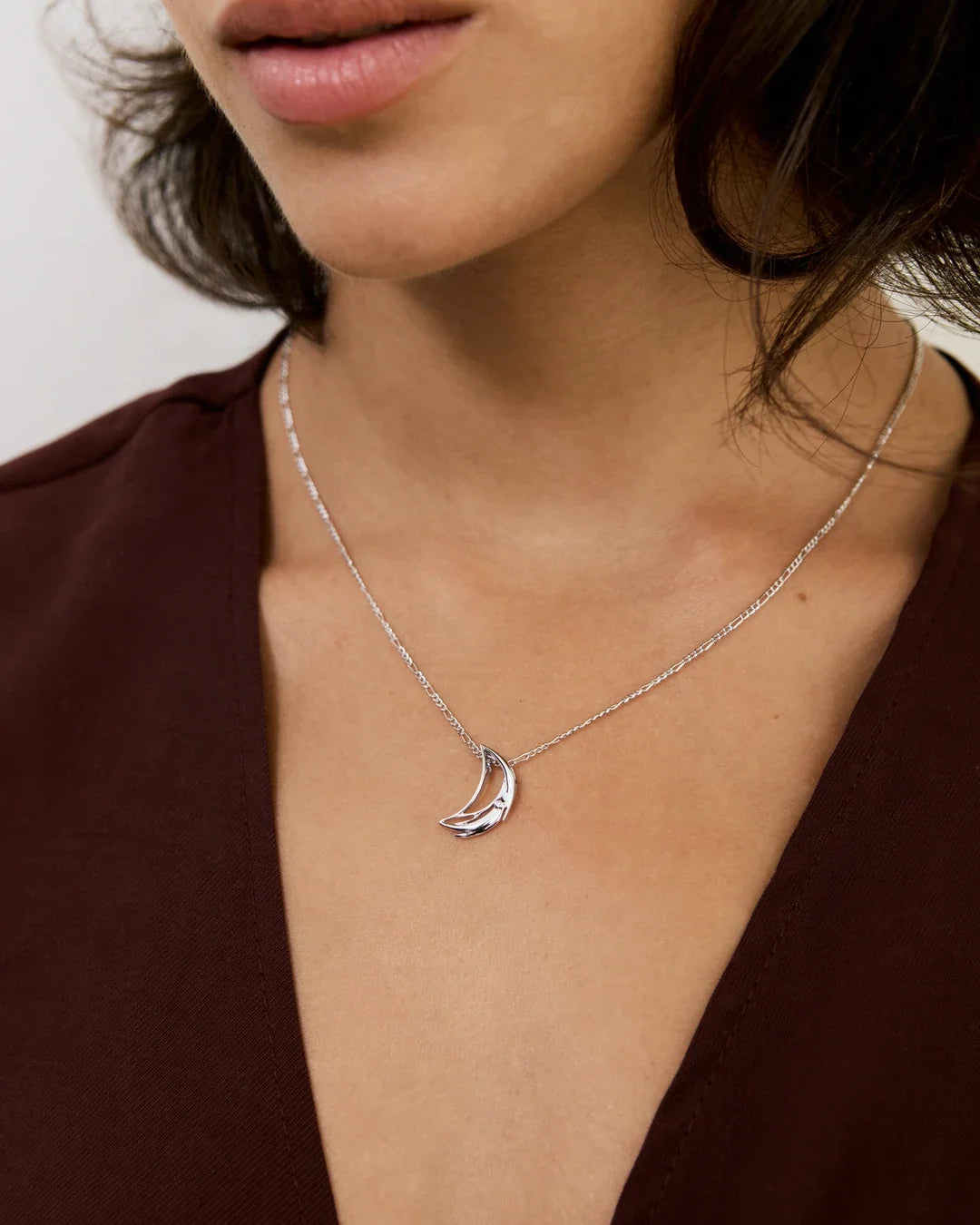 D डी Initial Necklace in silver-tone metal, featuring a delicate chain and a polished crescent-shaped pendant.