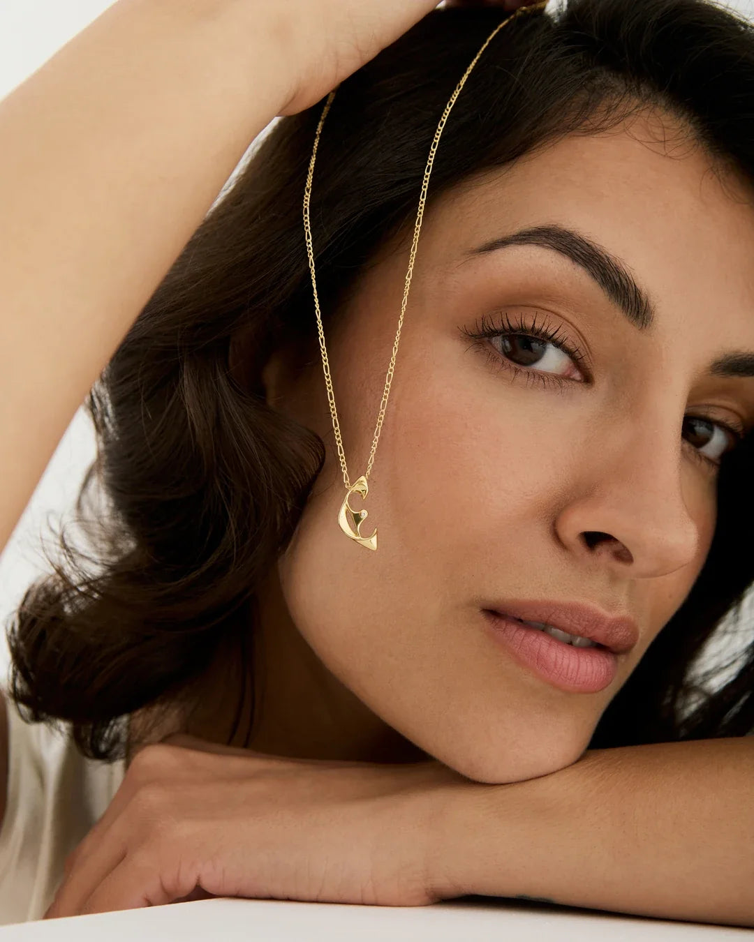 E ई Initial Necklace in delicate gold-tone metal, with a fine chain and small sculpted letter pendant.
