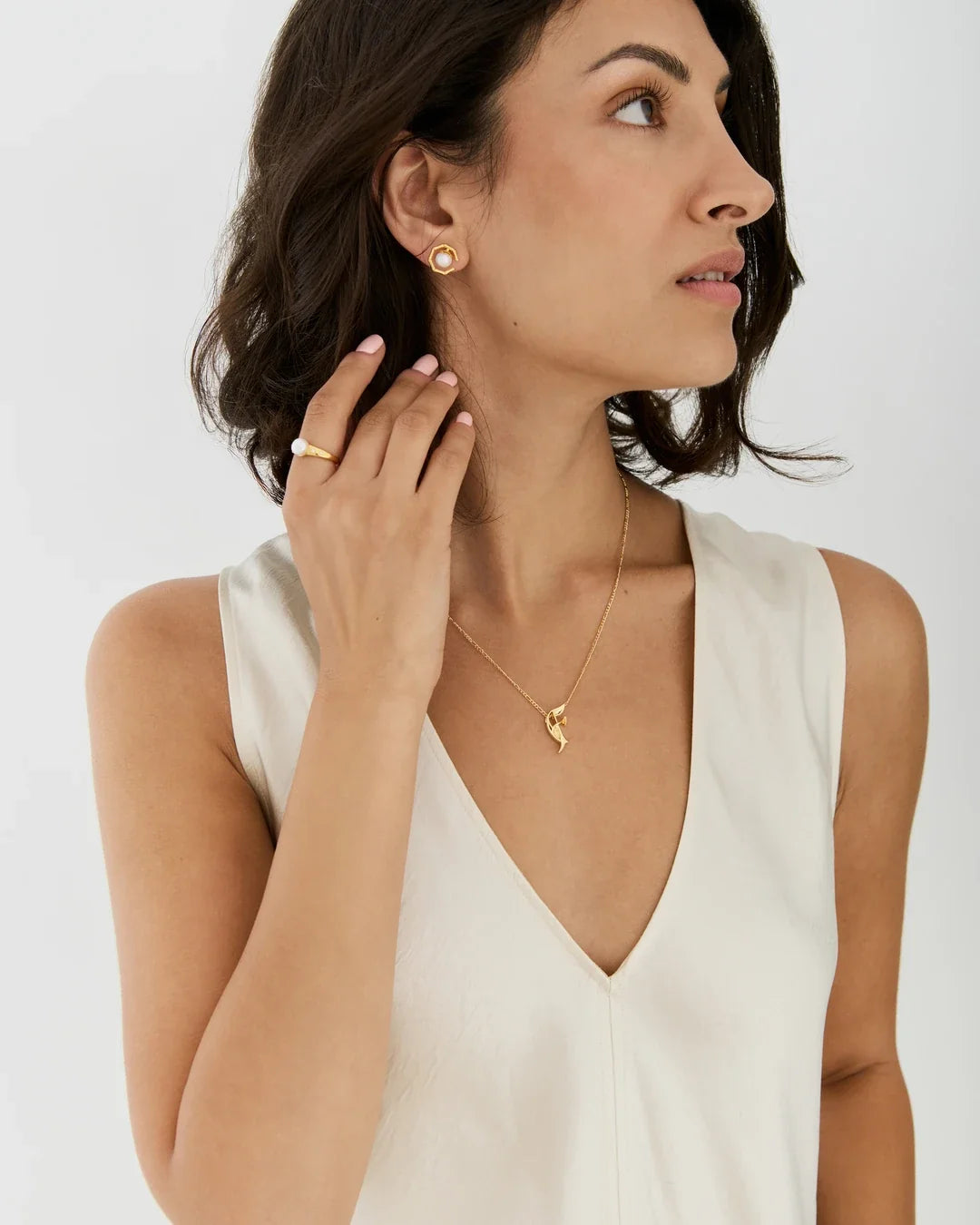 F एफ Initial Necklace in a delicate gold chain with a small gold letter F pendant, worn with matching stud earrings.