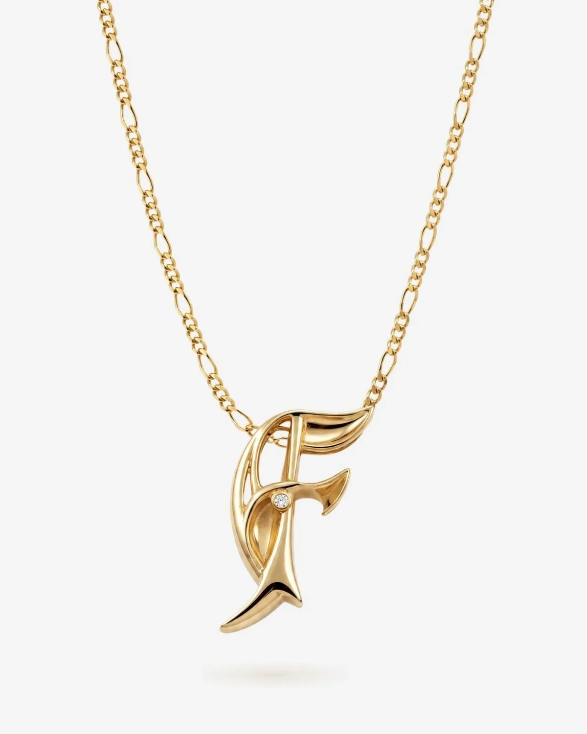 F एफ Initial Necklace in polished gold-tone metal, featuring an ornate F-shaped pendant with a small clear stone.