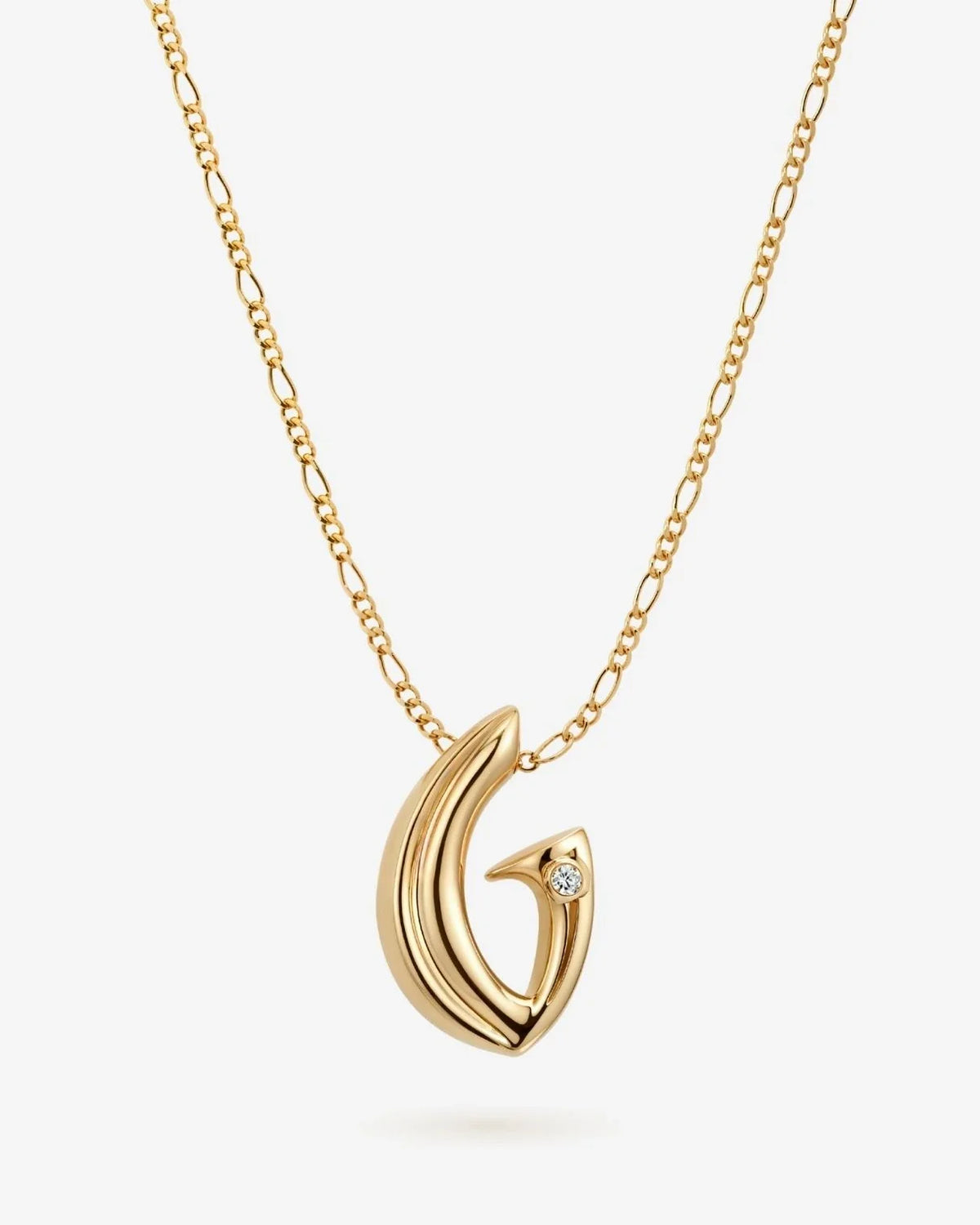 G जी Initial Necklace in polished gold-tone metal, with a sculptural G pendant and small clear stone accent.
