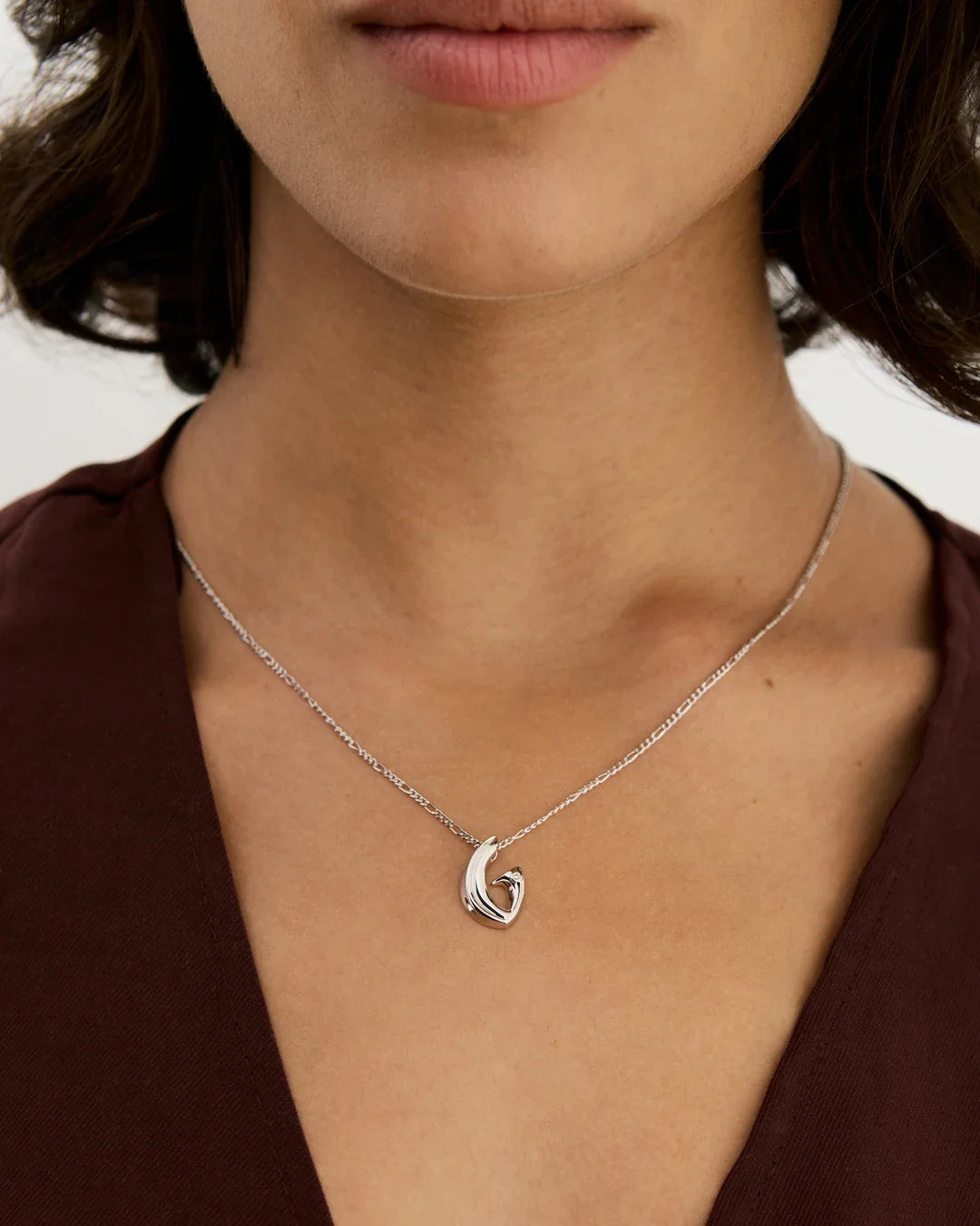 G जी Initial Necklace in polished silver-tone metal, with a delicate chain and sculpted G-shaped pendant featuring a curled detail.