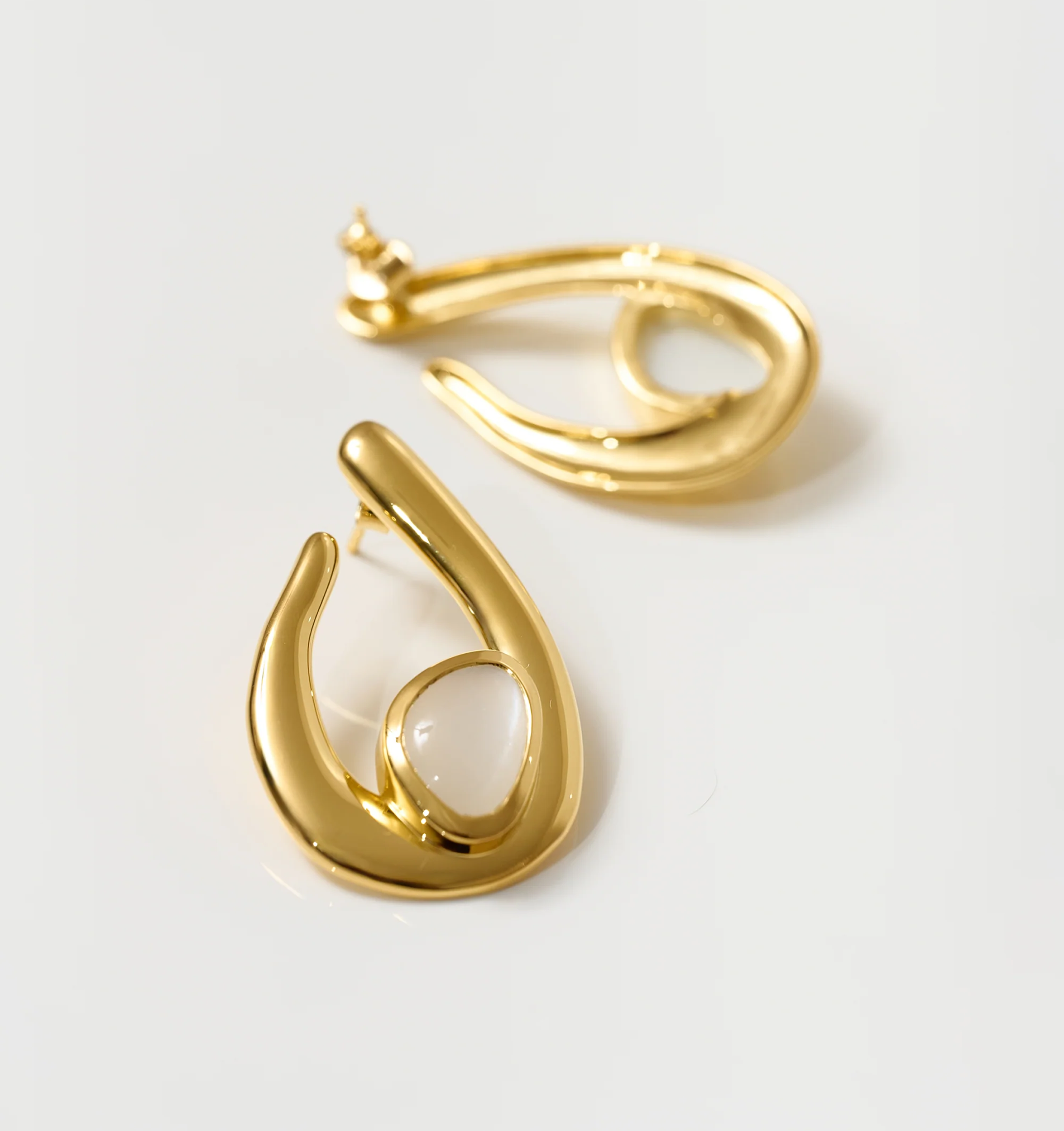 Lunara Earrings gold sculptural design with luminous white moonstone centerpiece