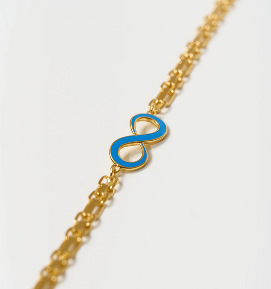 Avaanta Necklace with turquoise enamel infinity symbol on gold chain representing endless presence