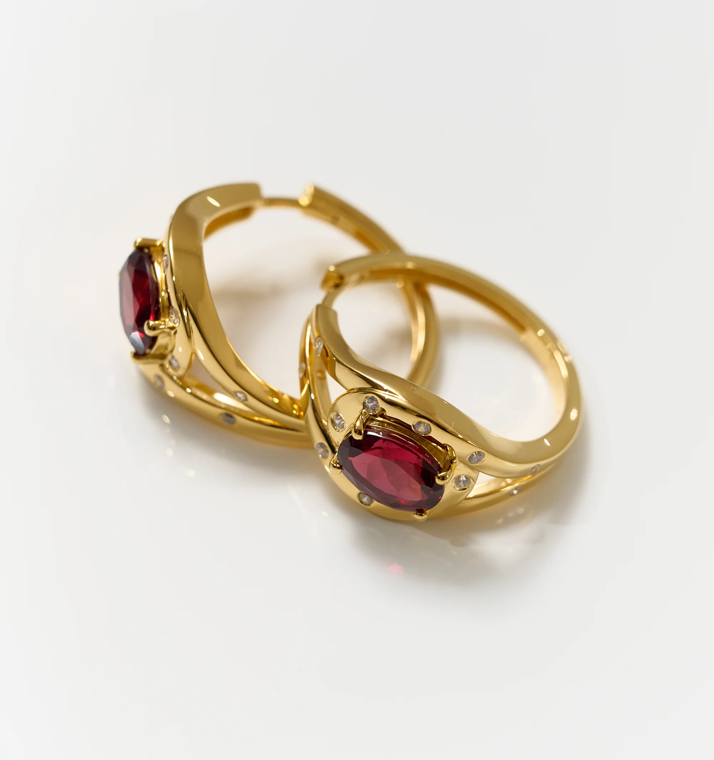Elegant gold Ruvya Hoops featuring garnet and white zircon gemstones