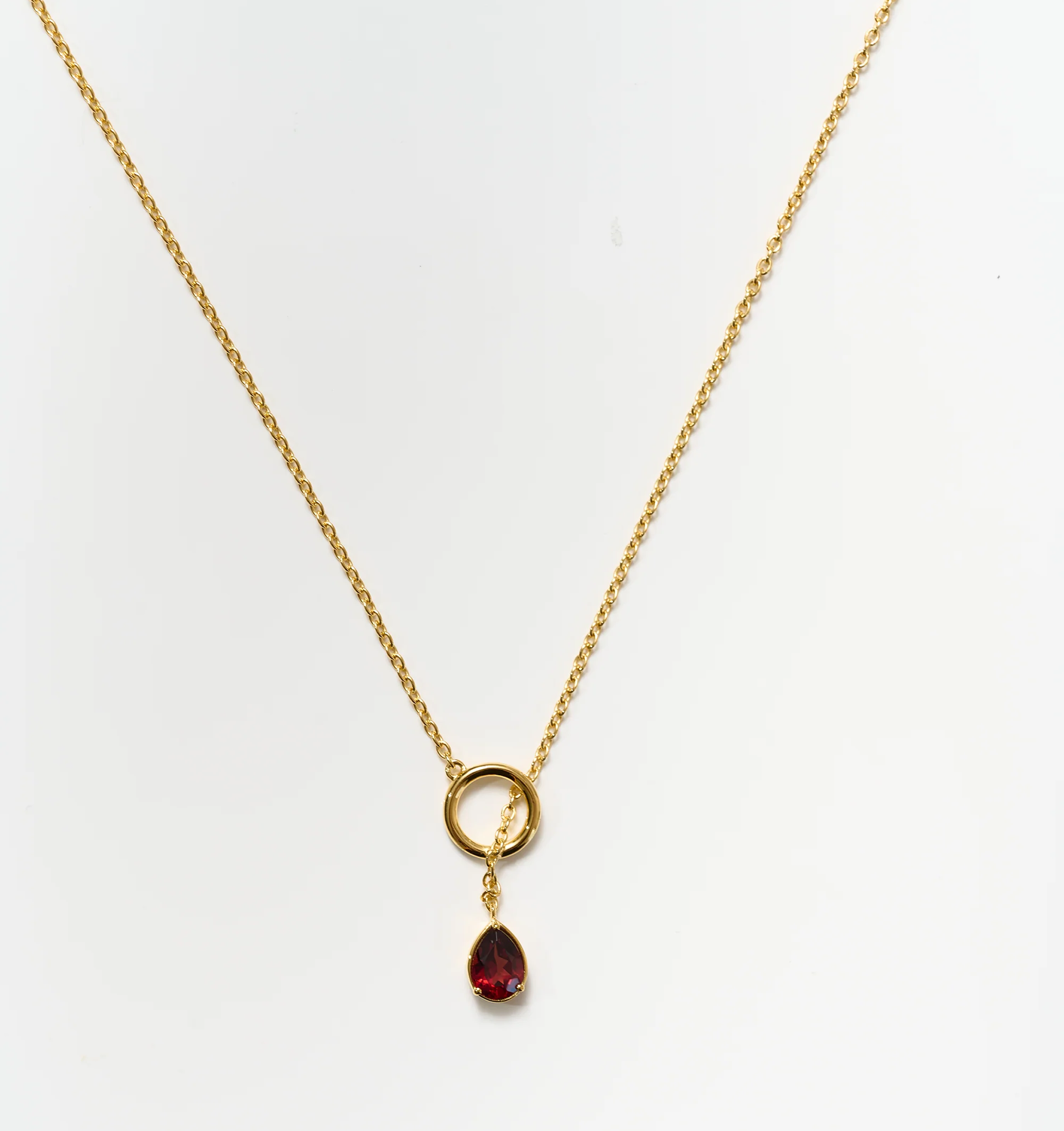 Agniti Necklace with a gold chain and a single teardrop garnet pendant symbolizing inner flame and grounding energy