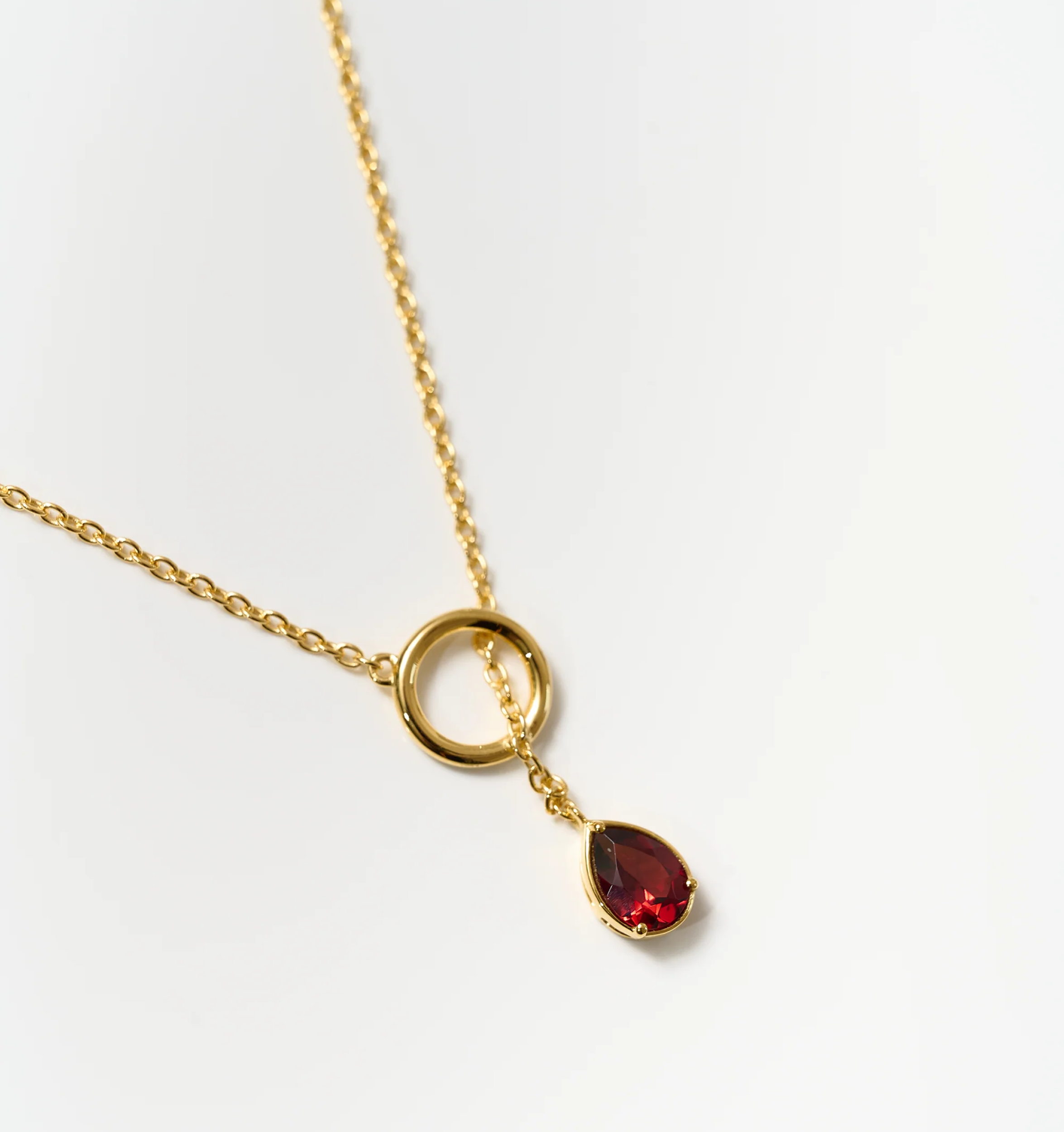Agniti Necklace with a gold chain and a teardrop-shaped red garnet pendant symbolizing an inner flame