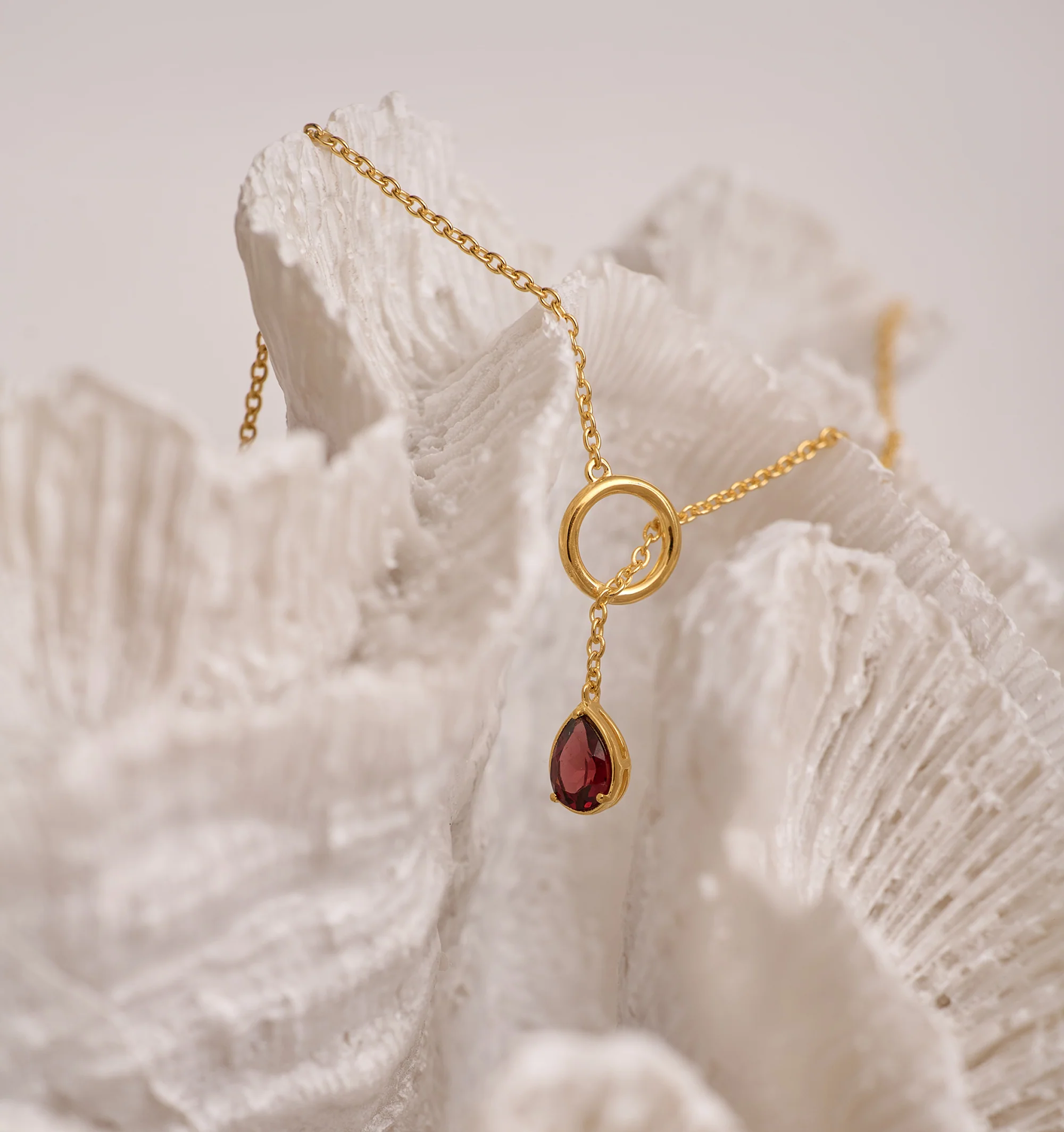 Agniti Necklace with gold chain and teardrop garnet pendant symbolizing inner flame and grounding energy