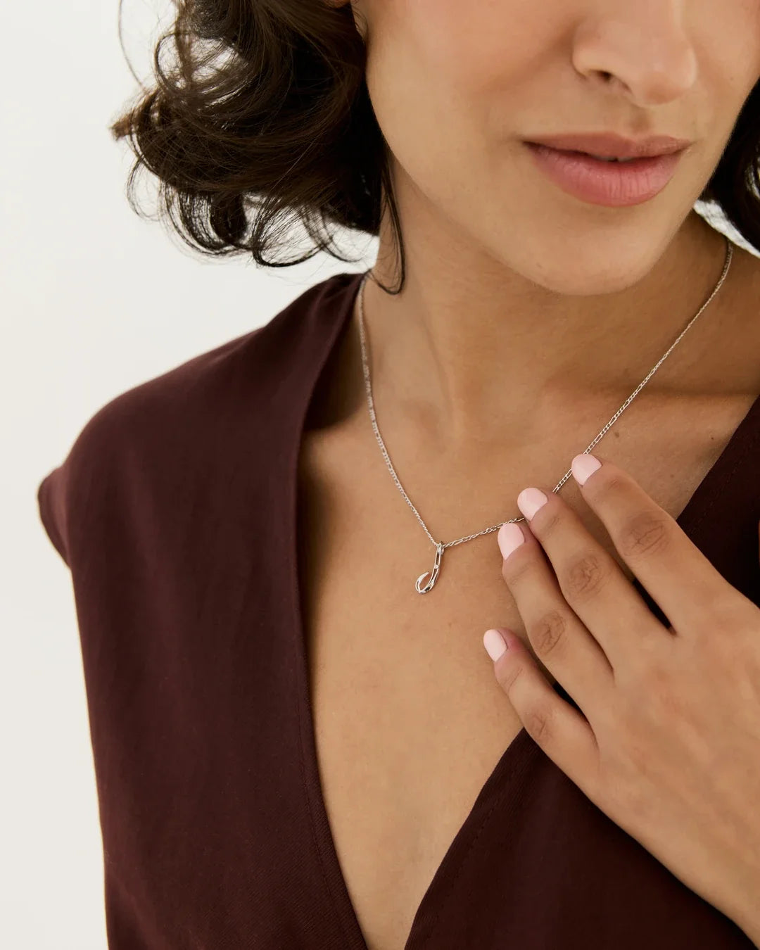 J जे Initial Necklace in silver-tone metal, featuring a delicate chain and a small letter J pendant with a curved finish.