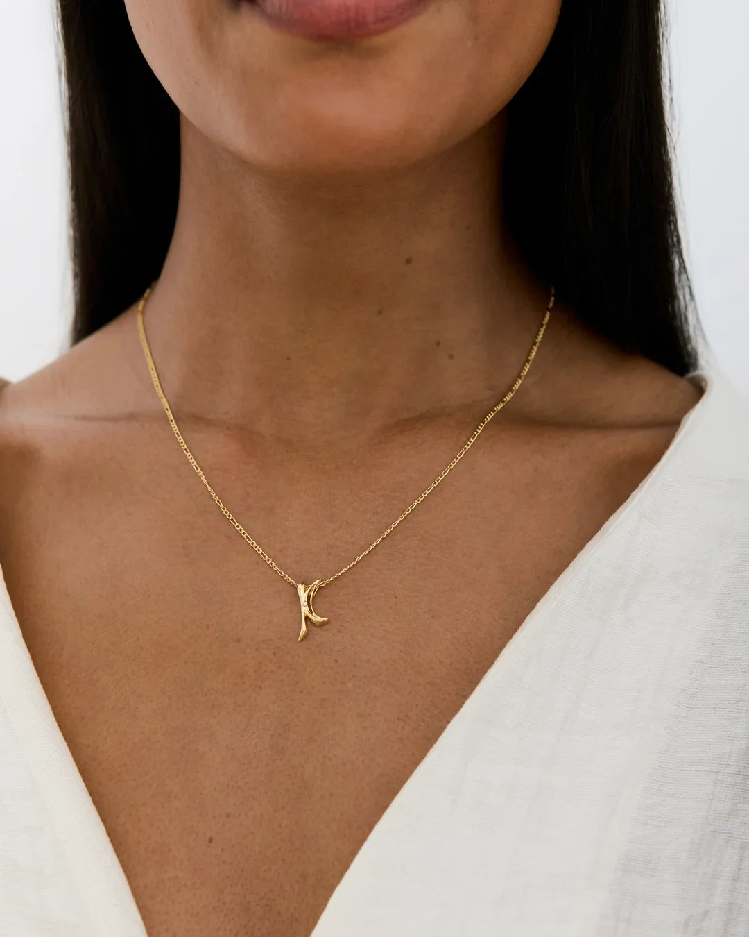 K के Initial Necklace in gold-tone metal, featuring a delicate chain and a sculpted K-shaped letter pendant.