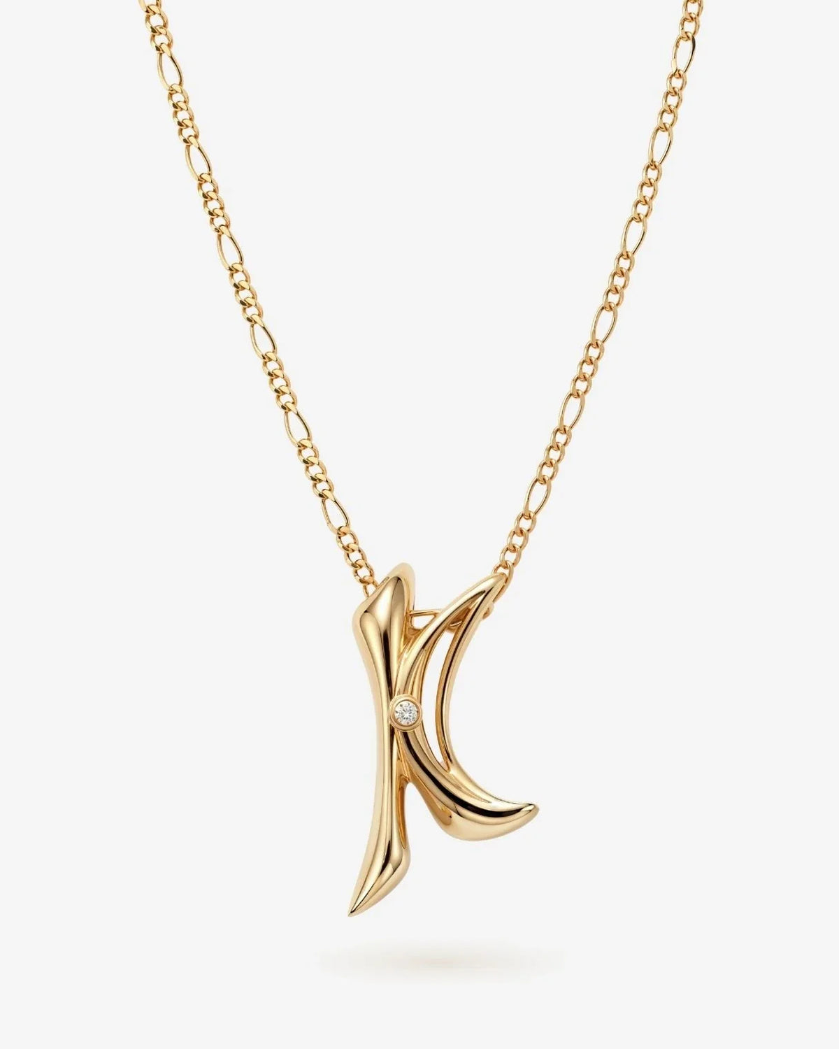 Gold-tone K के Initial Necklace with a sculpted letter K pendant and a small clear stone accent on a fine chain.
