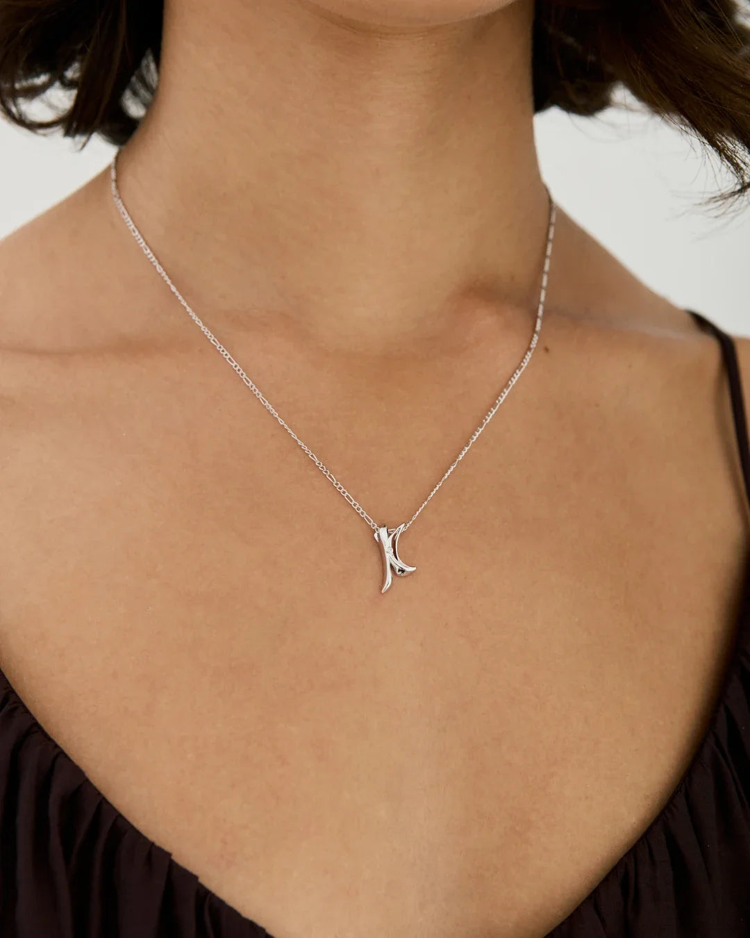 K के Initial Necklace in a fine silver-tone chain with a small polished K-shaped pendant and branching strokes.