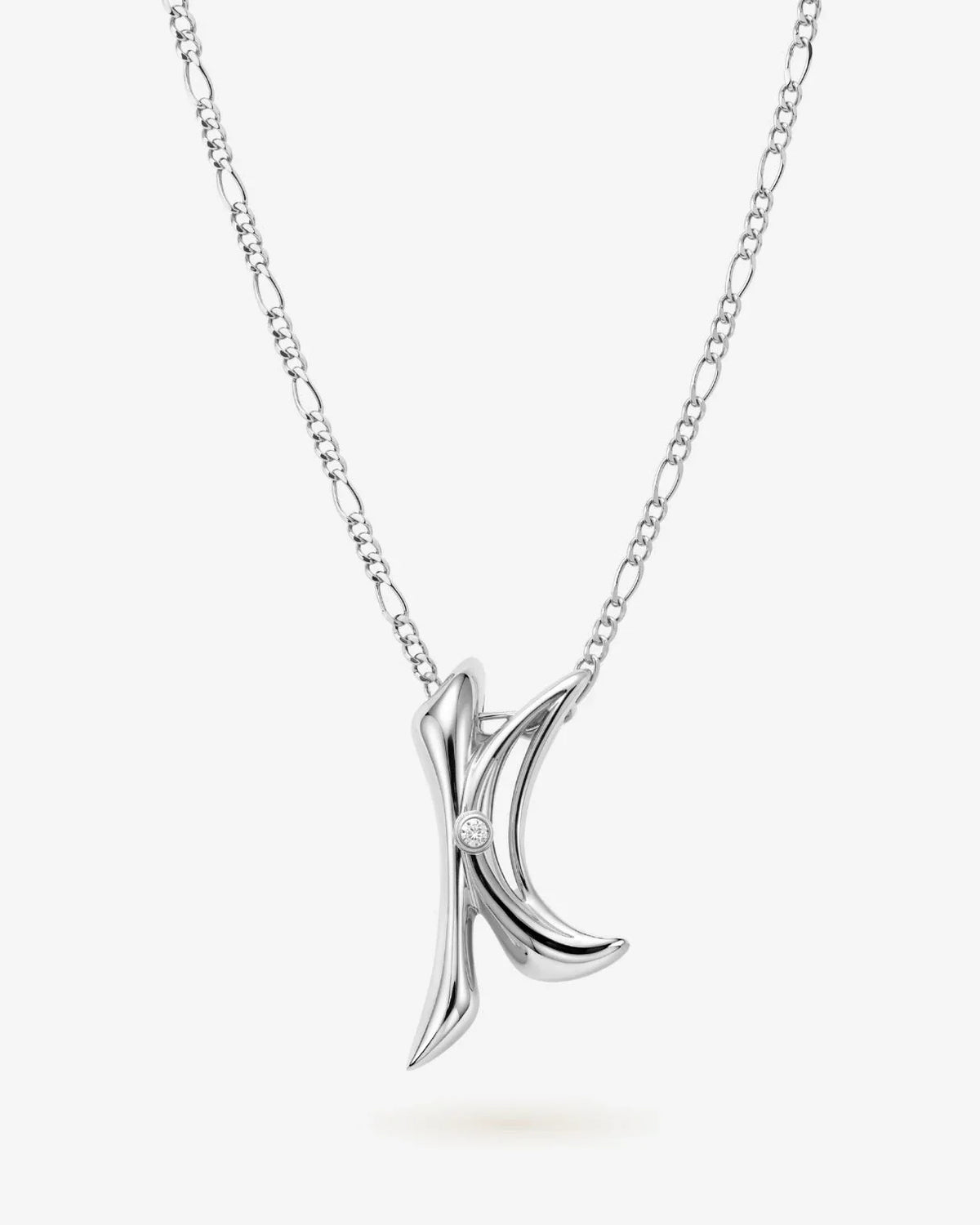 K के Initial Necklace in polished silver-tone metal, with a sculpted K pendant and small sparkling stone detail.