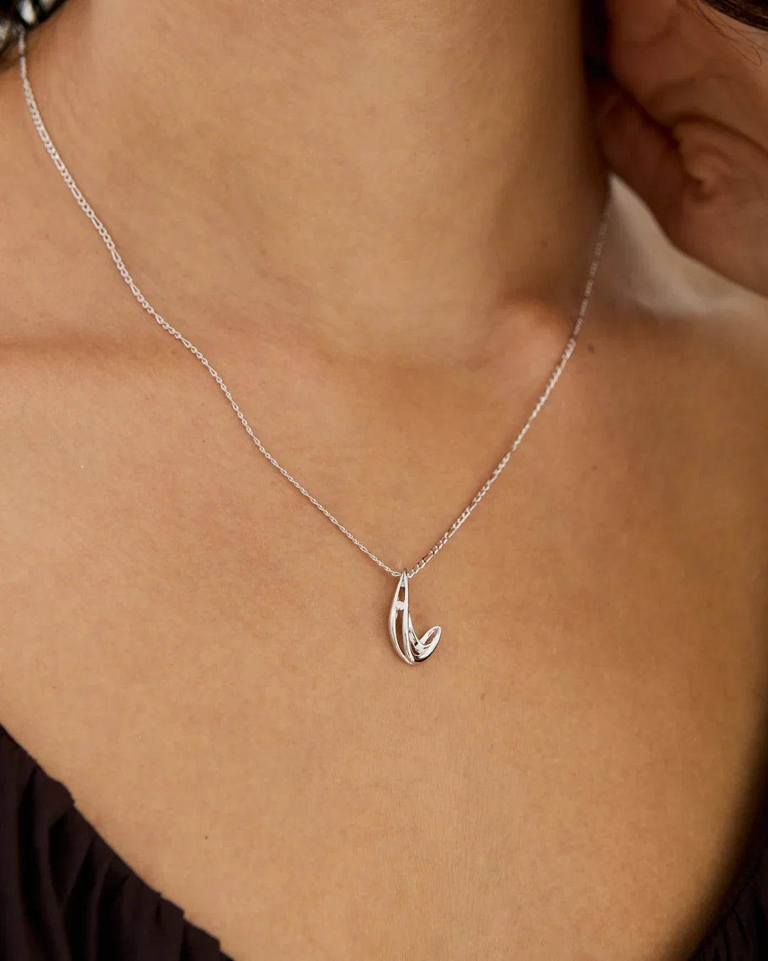 L एल Initial Necklace in silver-tone metal, with a fine chain and a small polished script L pendant with a sparkling accent.