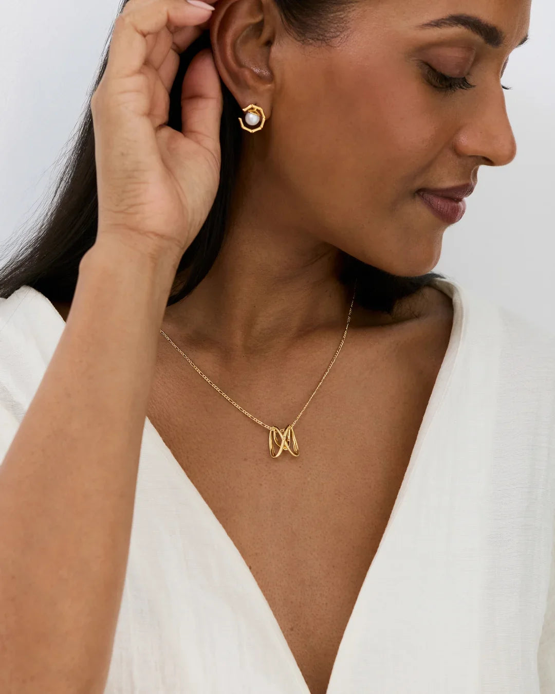 M एम Initial Necklace, a delicate gold-tone chain with an openwork M letter pendant and matching stud earrings.
