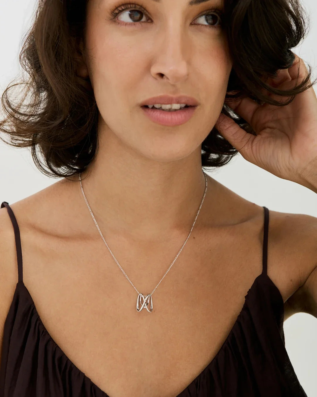 M एम Initial Necklace in silver-tone metal, with a delicate chain and a small flowing twin-peak letter pendant.