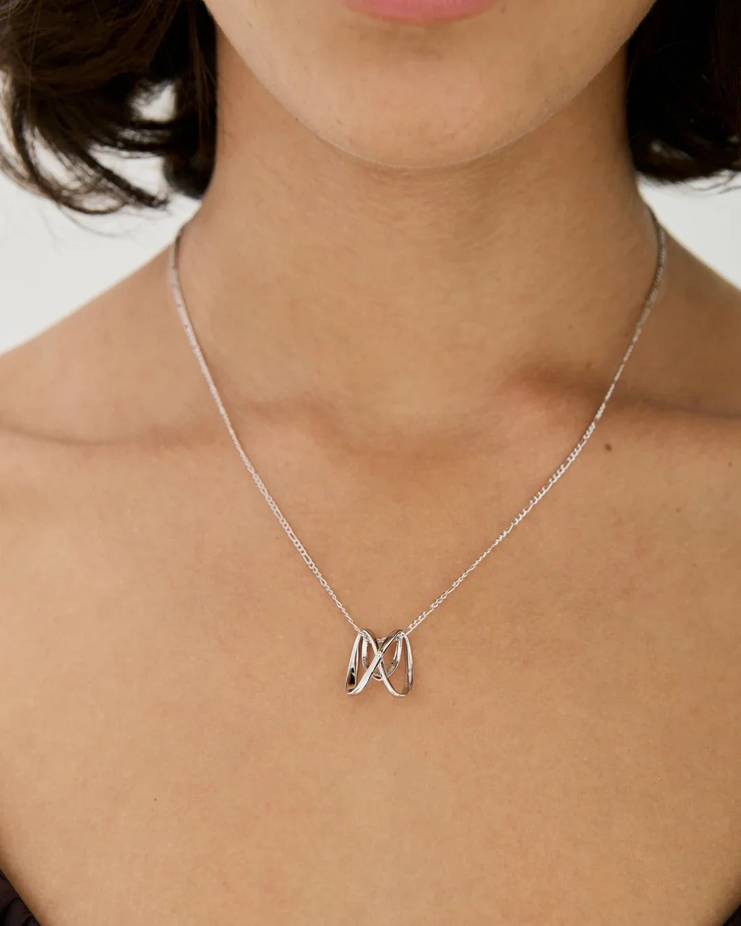 M एम Initial Necklace with a slim silver-tone chain and polished openwork M-shaped pendant, worn at the neckline.