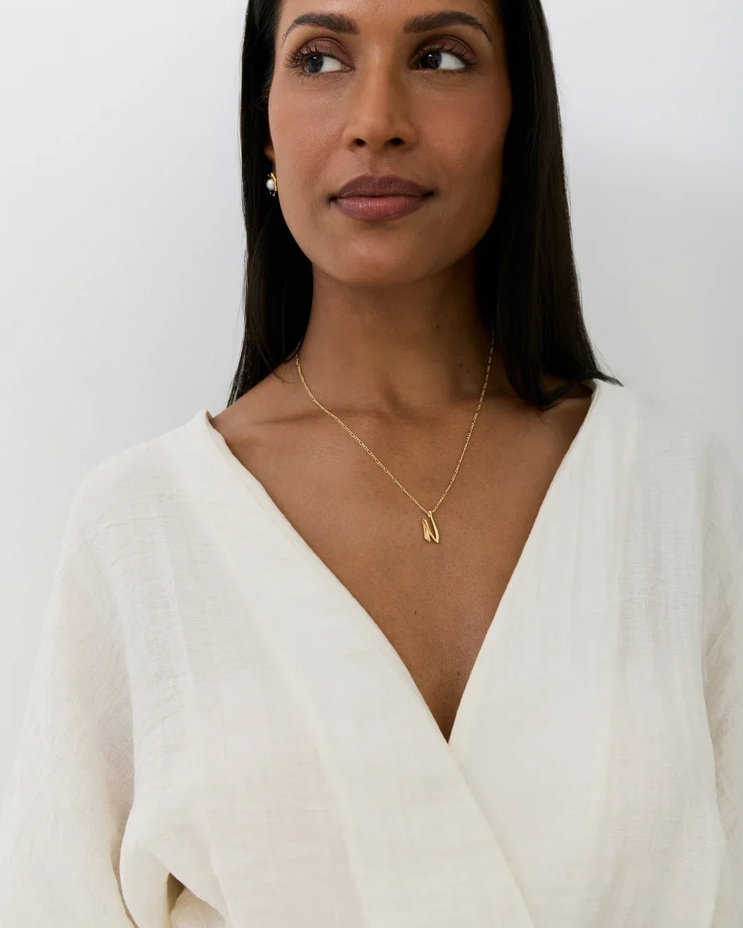 N एन Initial Necklace in gold-tone metal, featuring a fine chain and a small angular letter pendant.