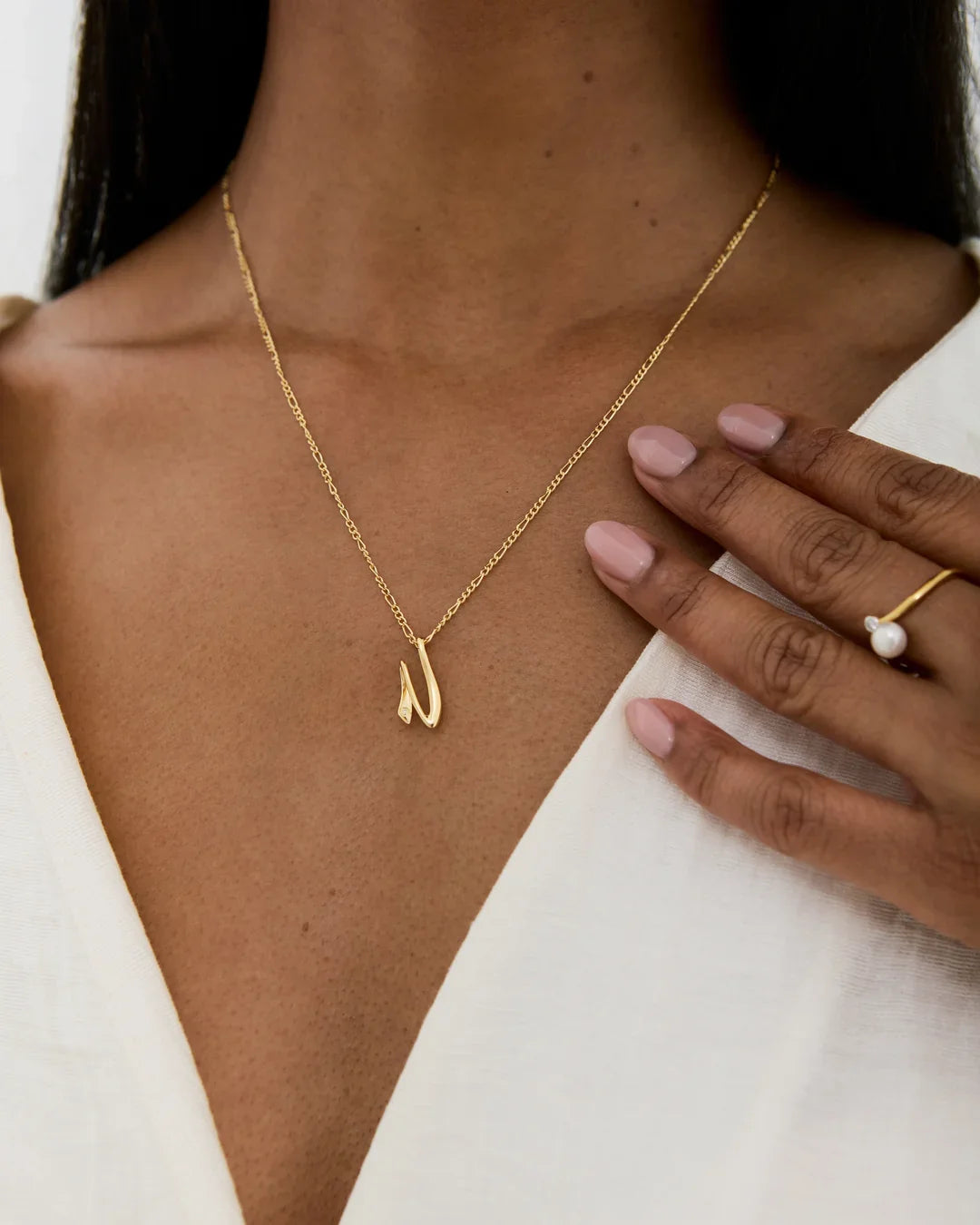 N एन Initial Necklace in a fine gold-tone chain, featuring a small polished N-shaped pendant.