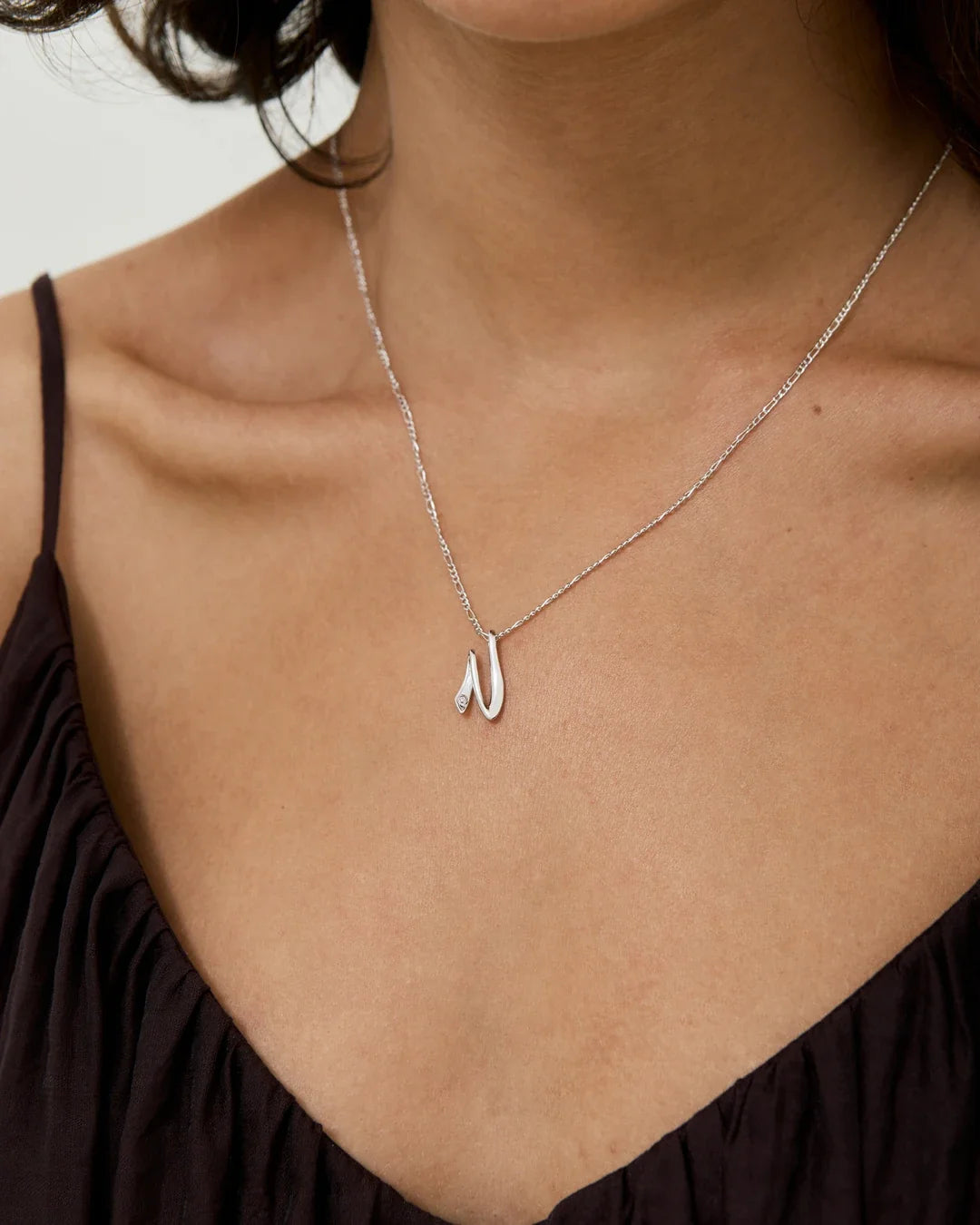 N एन Initial Necklace in polished silver with a delicate chain and slender N-shaped pendant.