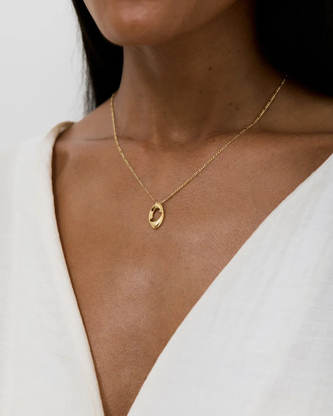 O ओ Initial Necklace in gold-tone metal, featuring a delicate chain and small oval pendant with an engraved character.