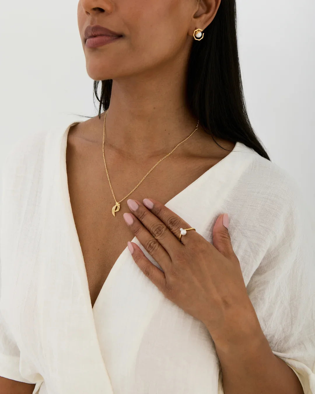 P पी Initial Necklace in a fine gold-tone chain with a small P-shaped pendant, paired with matching stud earrings.