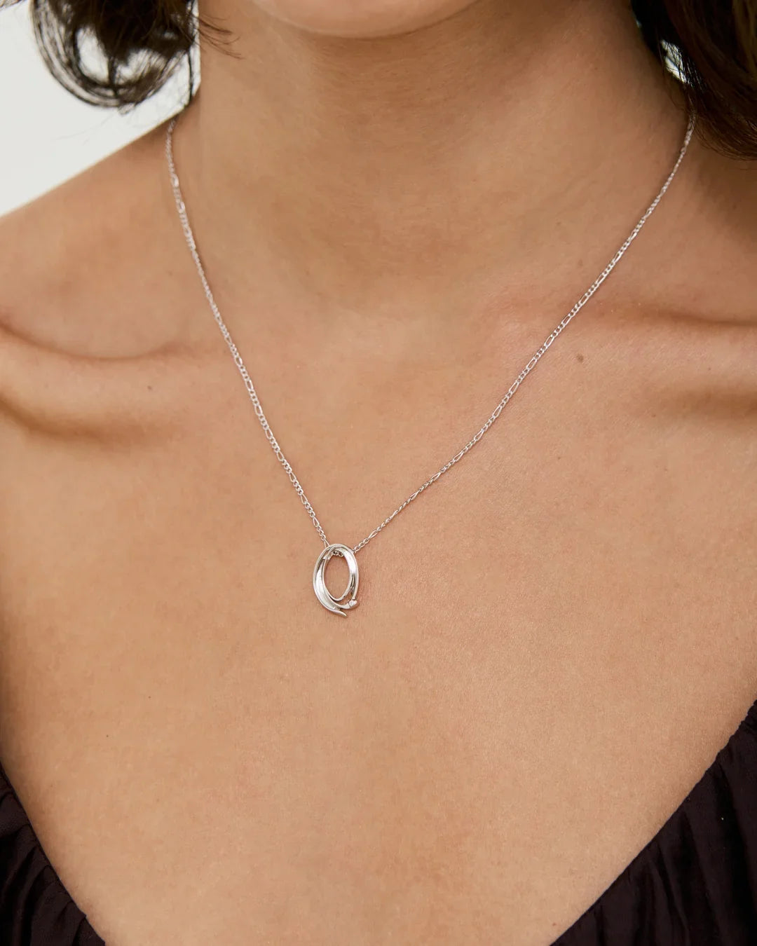 Q क्यू Initial Necklace, a delicate silver-toned chain with a polished open oval Q-shaped letter pendant.