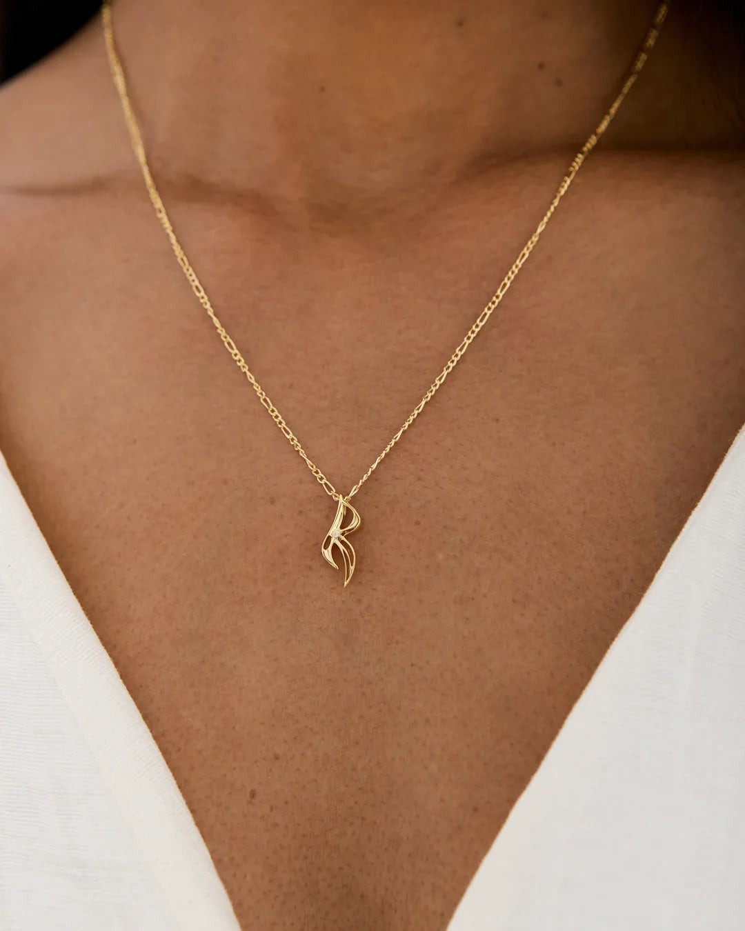 R आर Initial Necklace in gold-tone metal, with a delicate chain and a slim, sculpted letter R pendant.