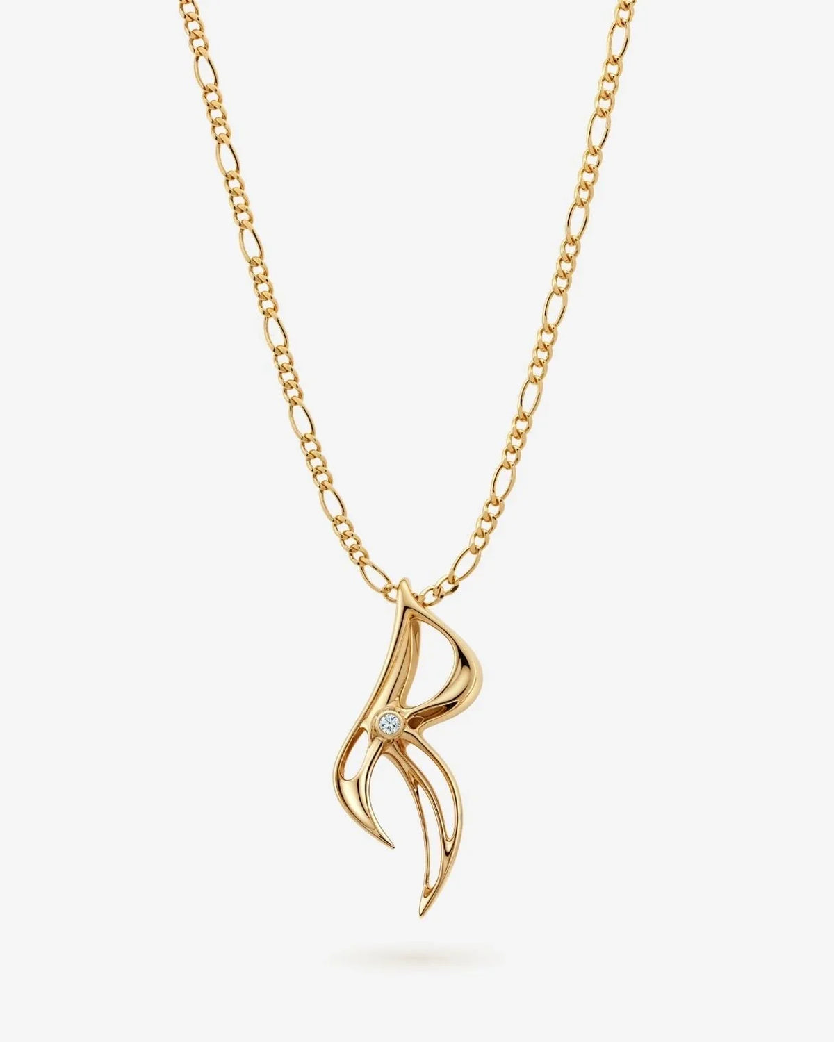 R आर Initial Necklace in gold-tone metal, featuring a slender sculptural R pendant with a small clear accent stone.