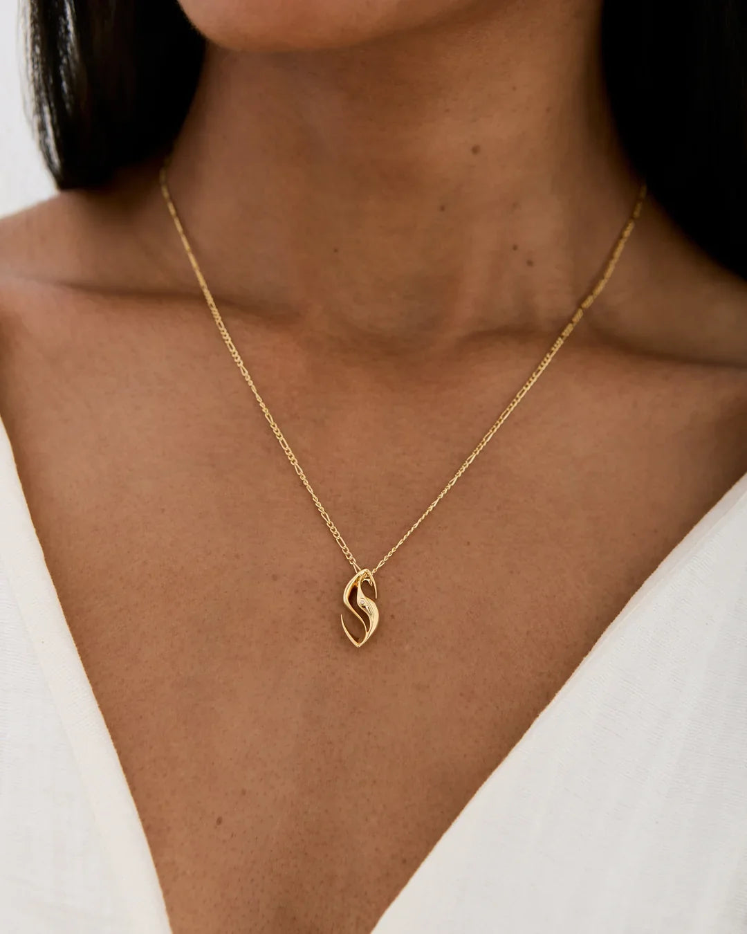 Gold-toned S एस Initial Necklace with a delicate chain and polished, flowing S-shaped pendant.