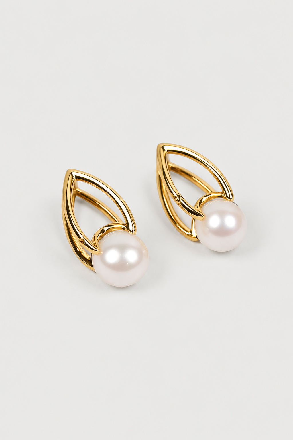 Shanta Earring featuring a luminous pearl in an open gold sculptural design symbolizing calm and strength