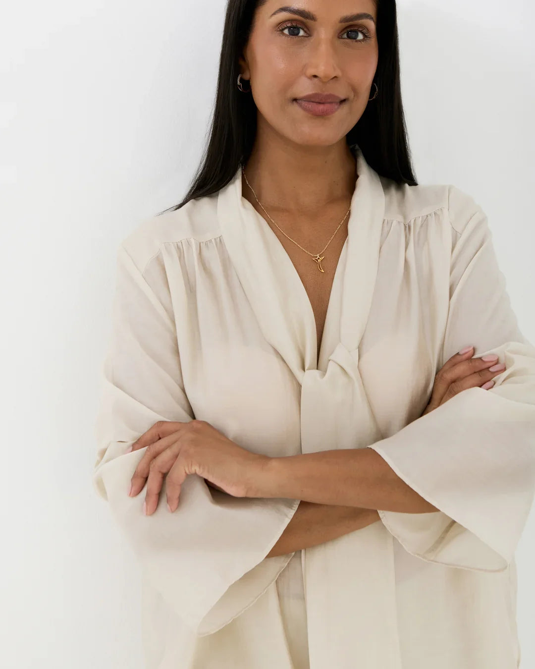 T टी Initial Necklace, delicate gold-tone chain with a small T-shaped pendant worn at the neckline
